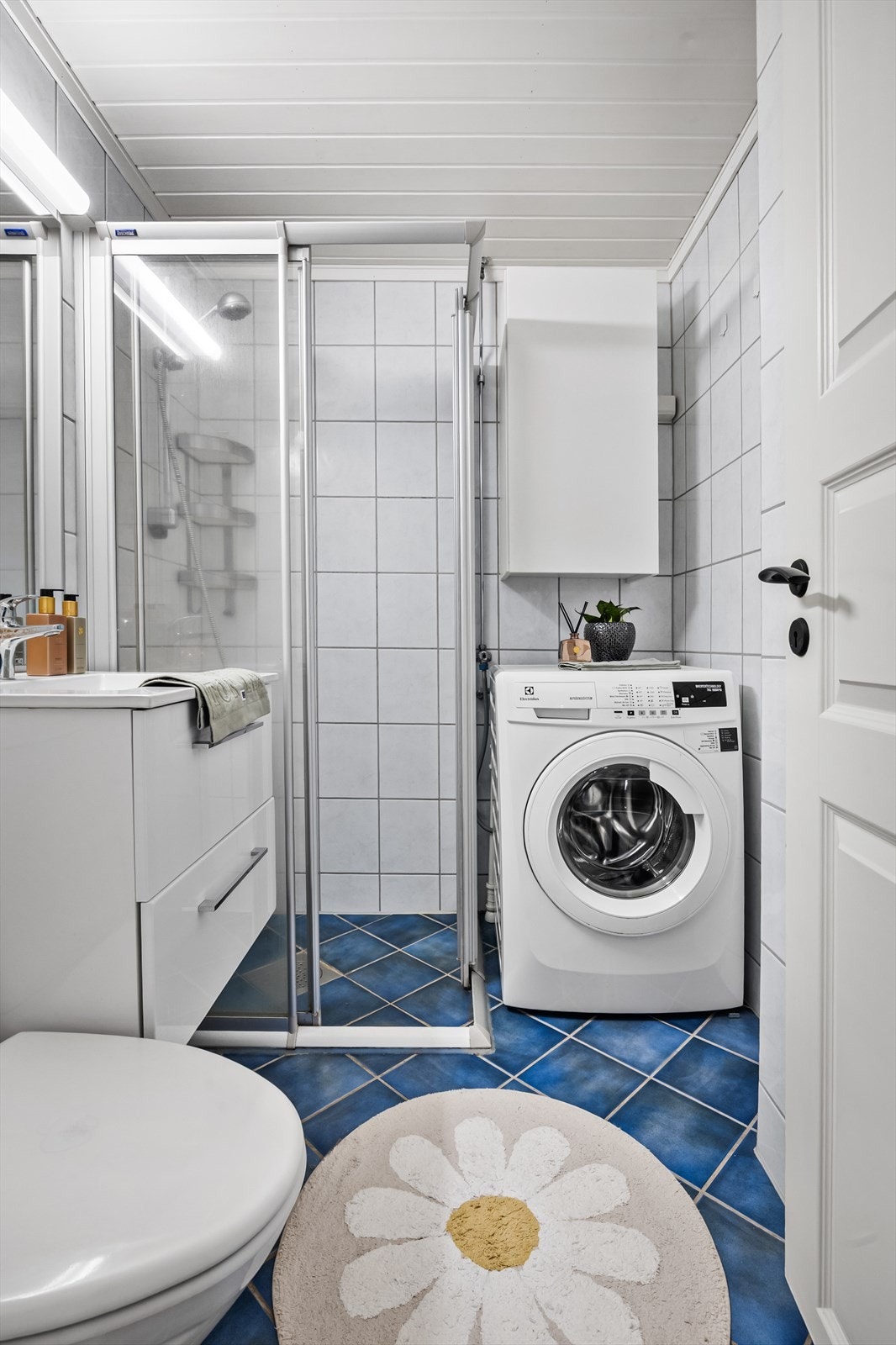 Her er det dusjhjørne, servantinnredning og praktisk opplegg for vaskemaskin. Galleribilde