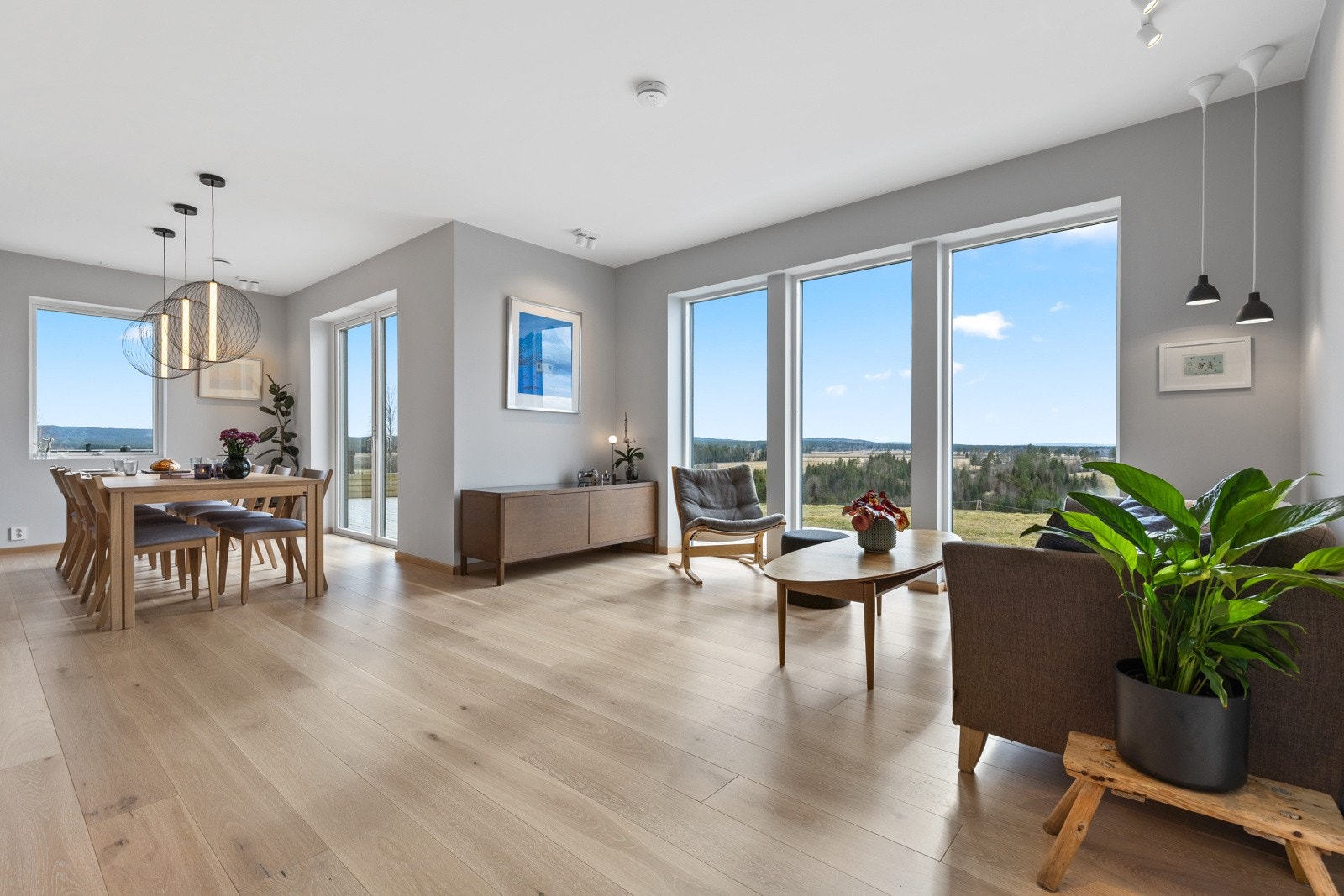 Den åpne stuen fremstår som meget tiltalende i delikate, tidsriktige fargevalg. På gulvet er det lagt nydelig lyspigmentert enstavs parkett med vannbåren gulvvarme, som strekker seg sømløst inn i kjøkkenet. Galleribilde