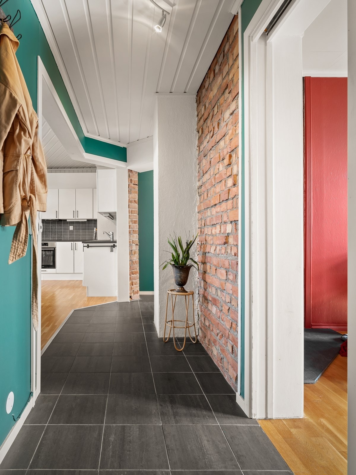 Entreen/gangen forbinder stuen med kjøkkenet og viser vei gjennom nesten hele leiligheten. Under gulvflisene er det varme. Galleribilde