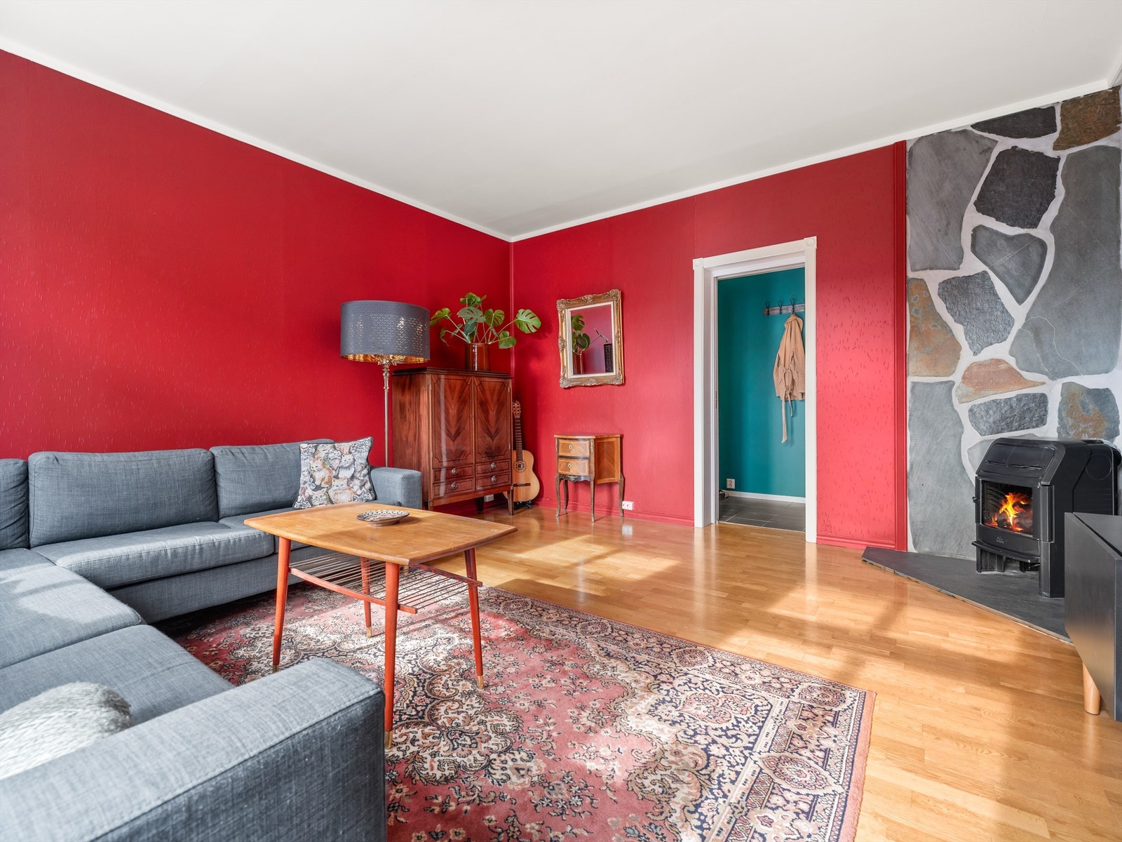 Stuens ildsted er like varmende som stemningsfremmende. Skorsteinen ble renovert i regi av sameiet i 2022. Galleribilde