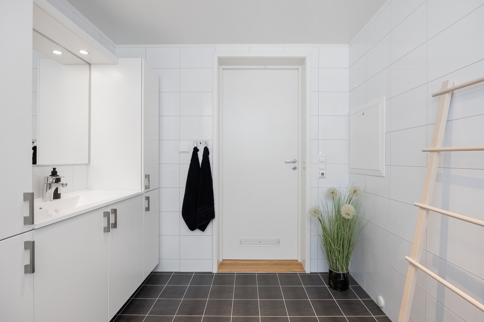 Vegghengt speil med lys over. Vegghengt toalett med innbygd sisterne. Fliser på gulv og vegger. Varmekabler i gulv og downlights i nedsenket himling Galleribilde