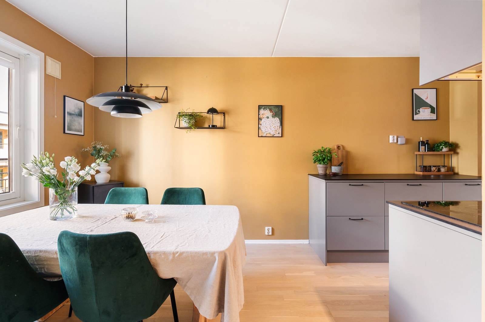 Det delvis åpne kjøkkenet har en hyggelig spiseplass foran vinduet. Galleribilde