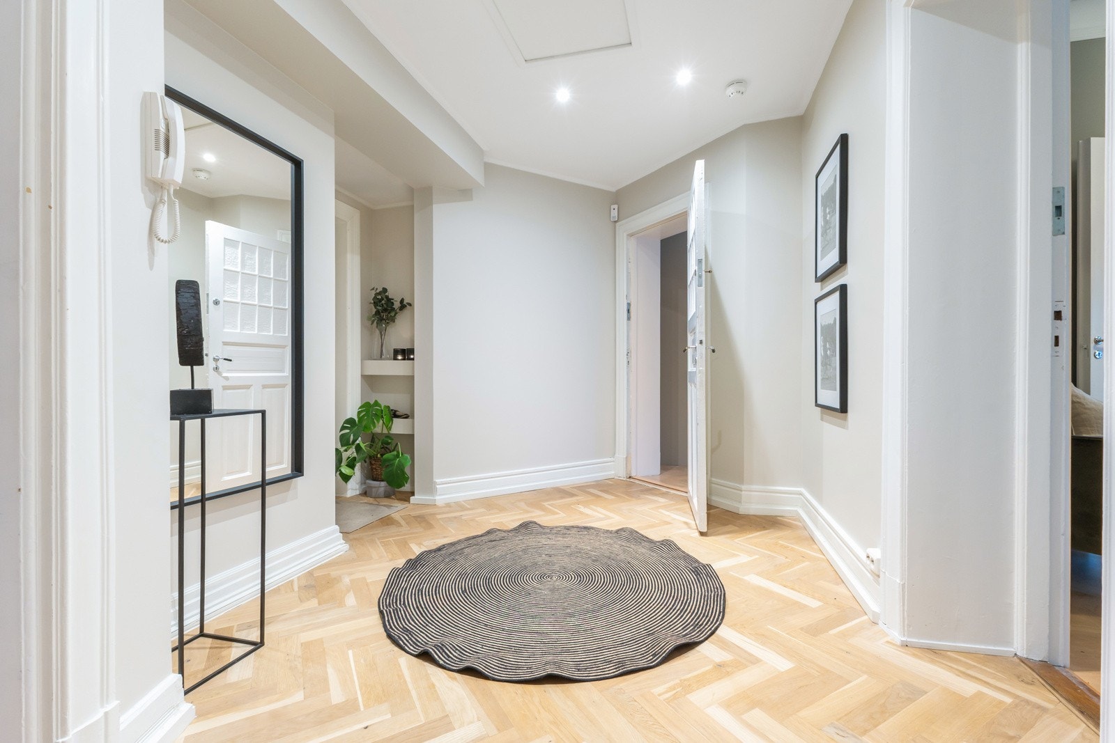 Lys og harmonisk mellomgang som leder videre til boligens private sone. Galleribilde