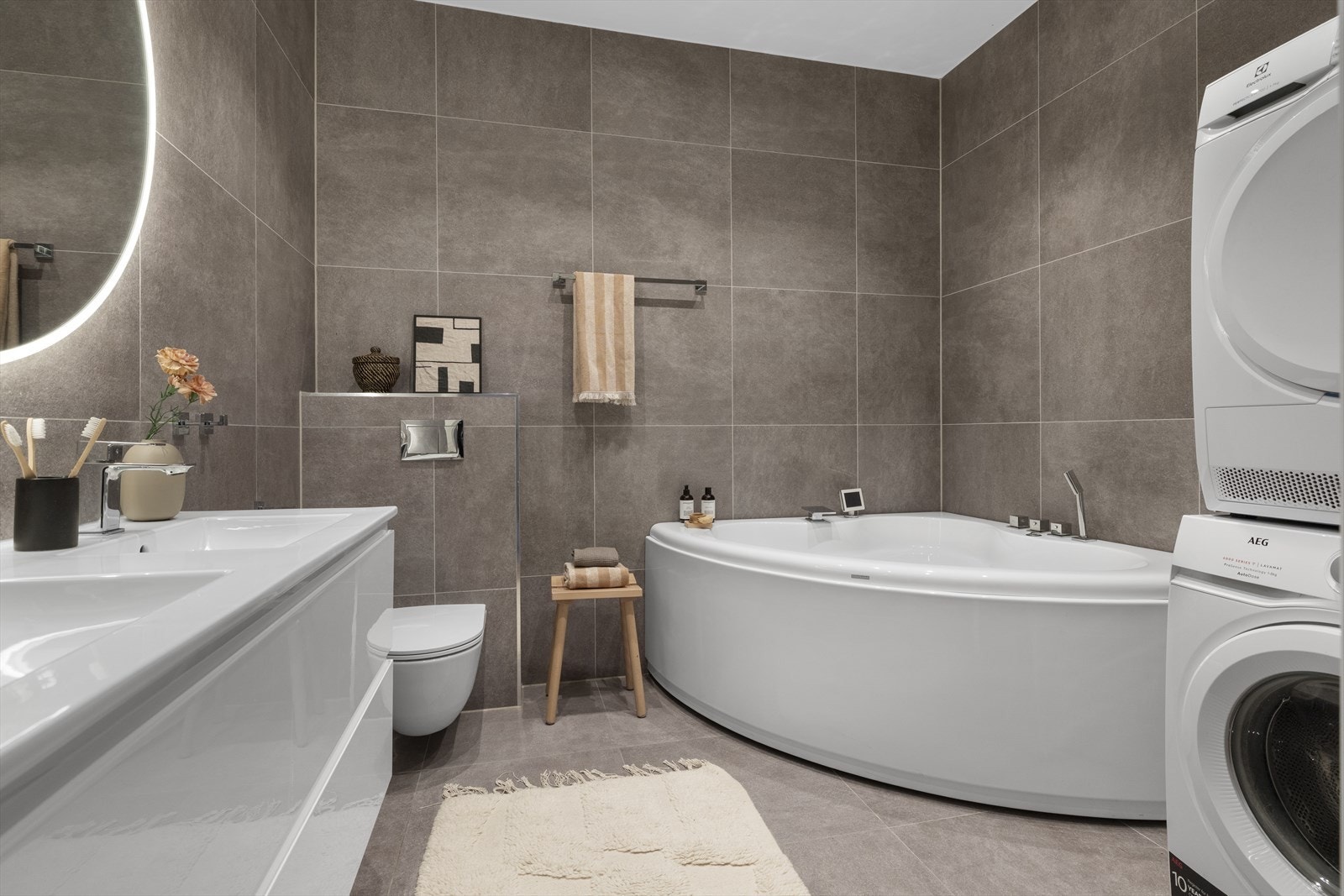 Romslig hovedbad med blant annet hjørnebadekar og opplegg for vaskesøyle Galleribilde