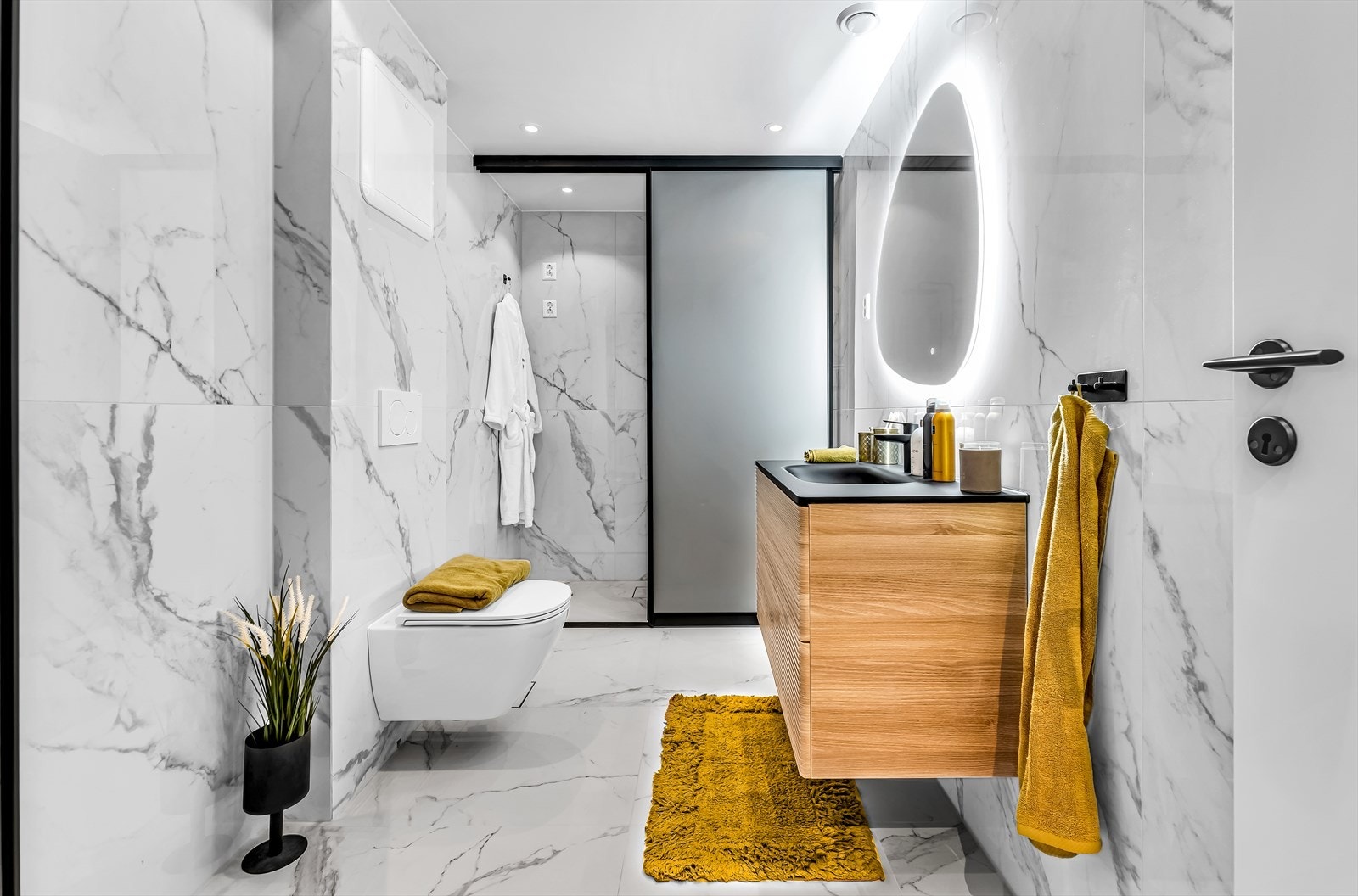 Badet har rene linjer og moderne overflater. Vegghengt toalett med innebygget sisterne. Skuffeinnredning med heldekkende servant og ett-greps blandebatteri. Galleribilde