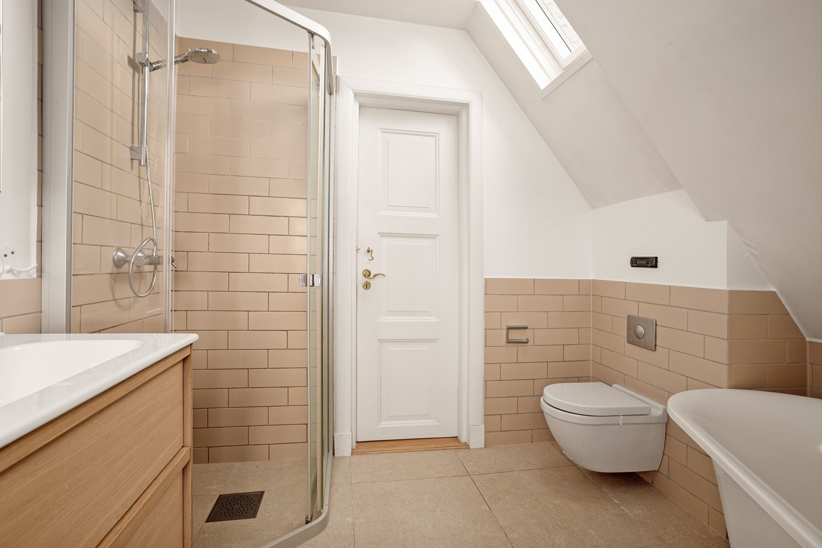 Baderommet har innglasset dusjhjørne og vegghengt servant med doble armaturer. Galleribilde