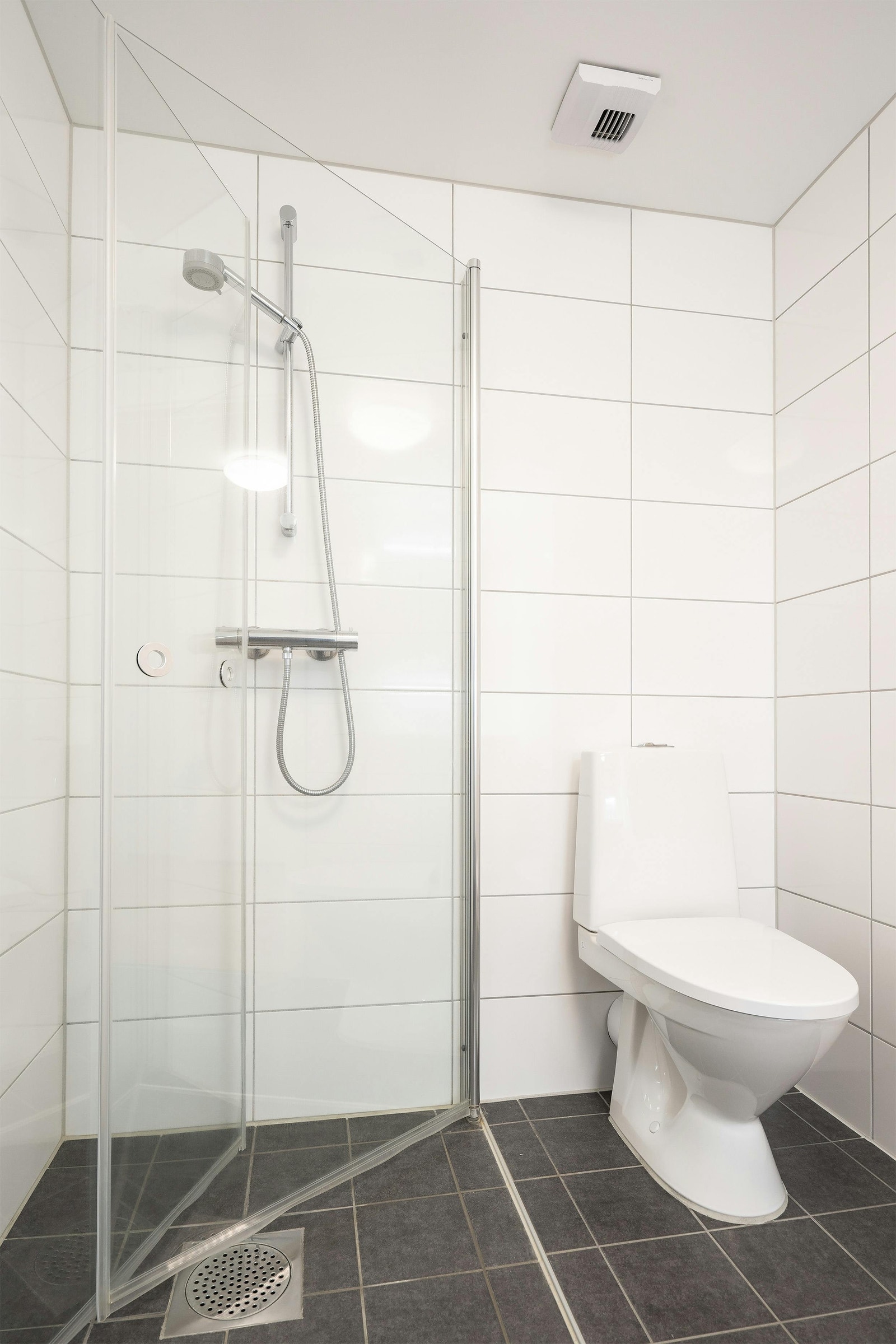 Flislagt lyst bad med dusjdører i herdet glass Galleribilde