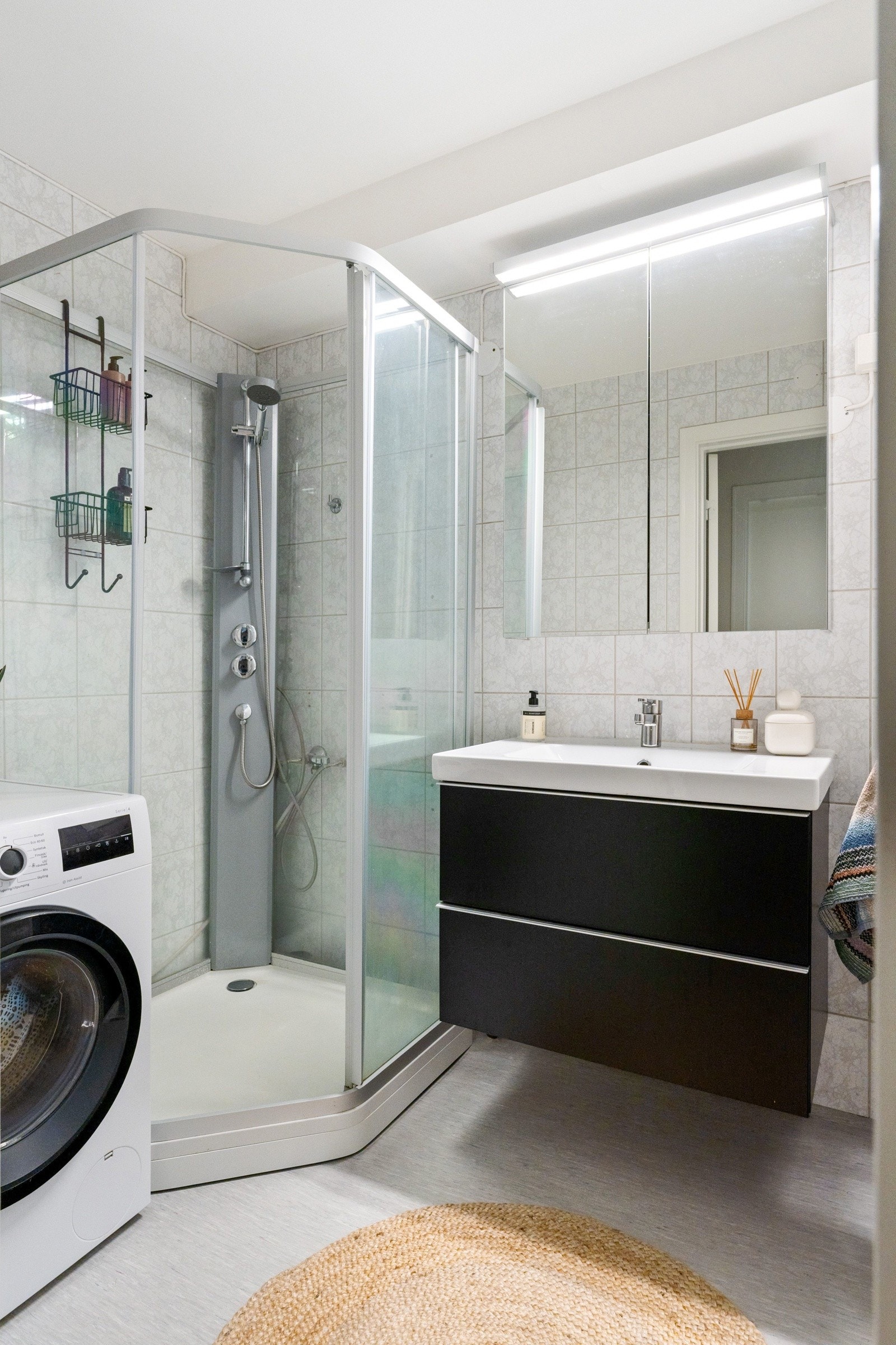 Baderommet er lyst og funksjonelt og er utstyrt med et dusjkabinett fra 2022, servant med underskap, speilskap samt opplegg for vaskemaskin. Galleribilde