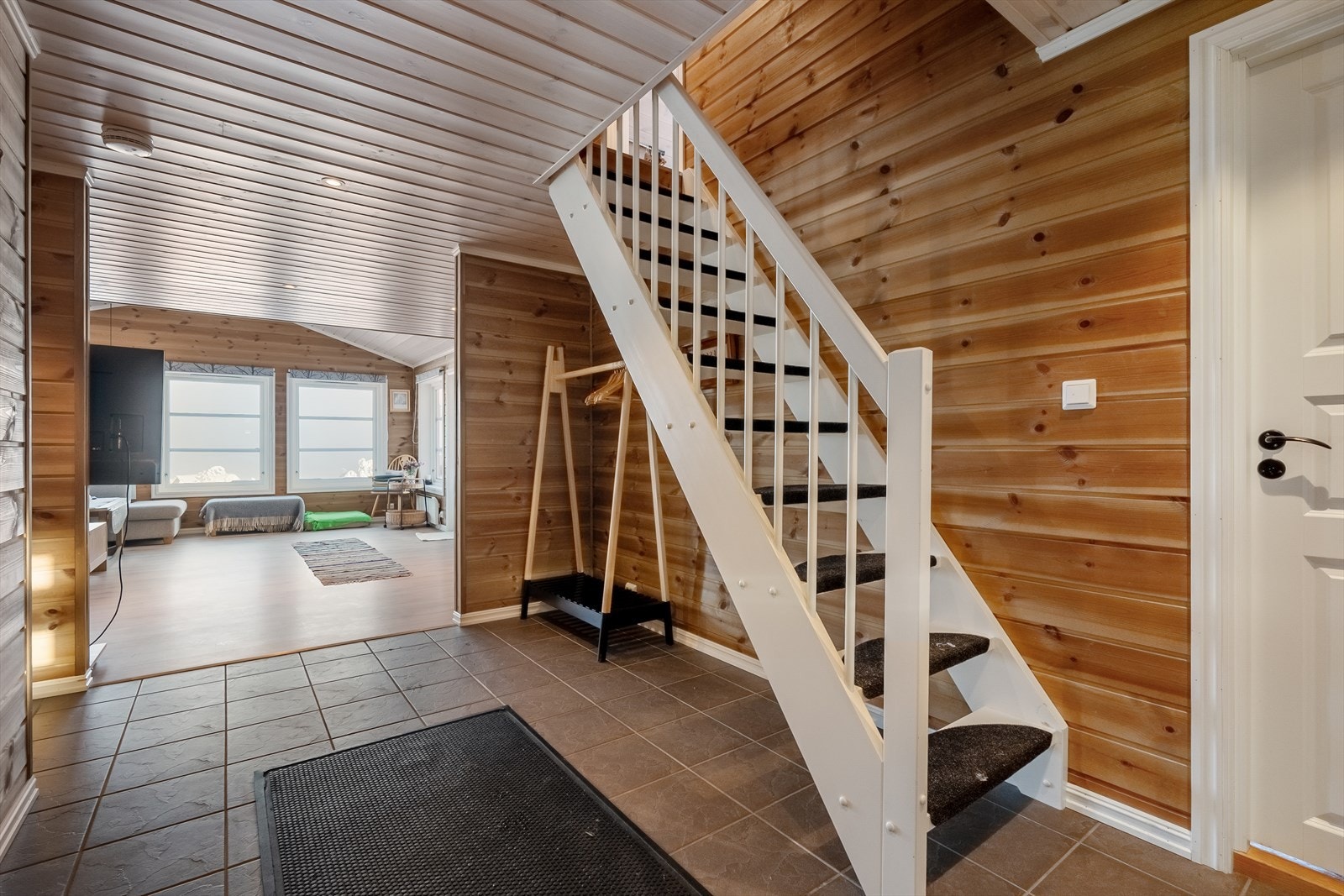 Velkommen inn! Romslig entré med fliser på gulv og panelkledde vegger. Det er godt med plass til klesoppbevaring. Galleribilde