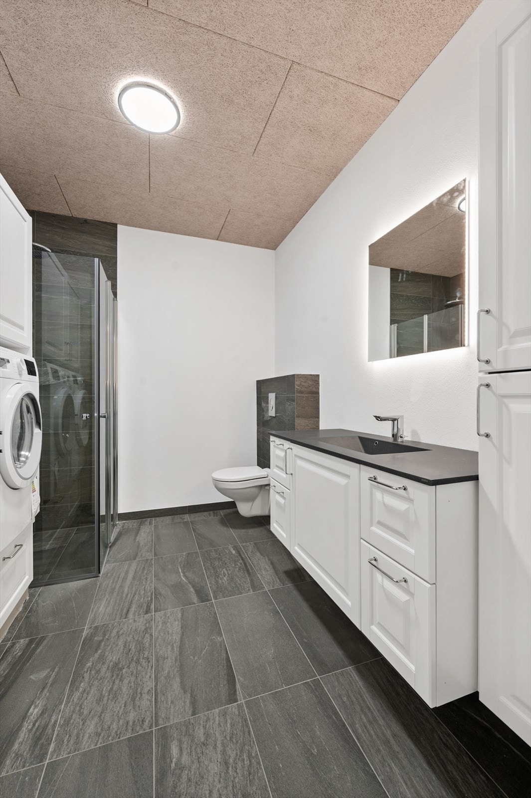 Bad/wc/vaskerom - Dusjhjørne, veggehengt klosett, baderomsinnredning, speil med belysning. Galleribilde