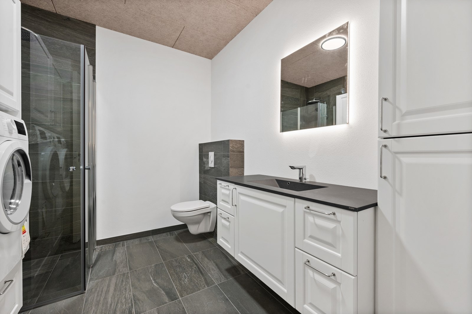 Bad/wc/vaskerom - Dusjhjørne, veggehengt klosett, baderomsinnredning, speil med belysning. Galleribilde