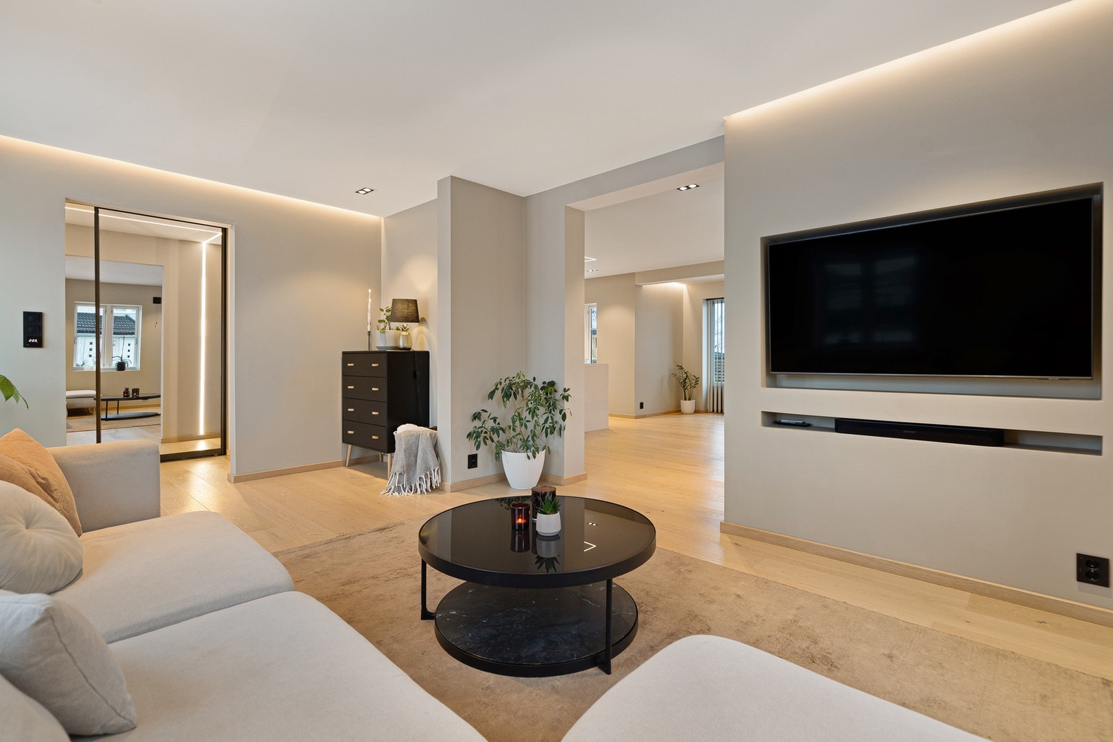 Tv-stua fører deg videre inn mot kjøkkenet, samt at det er doble dører ut til hagen fra dette rommet Galleribilde