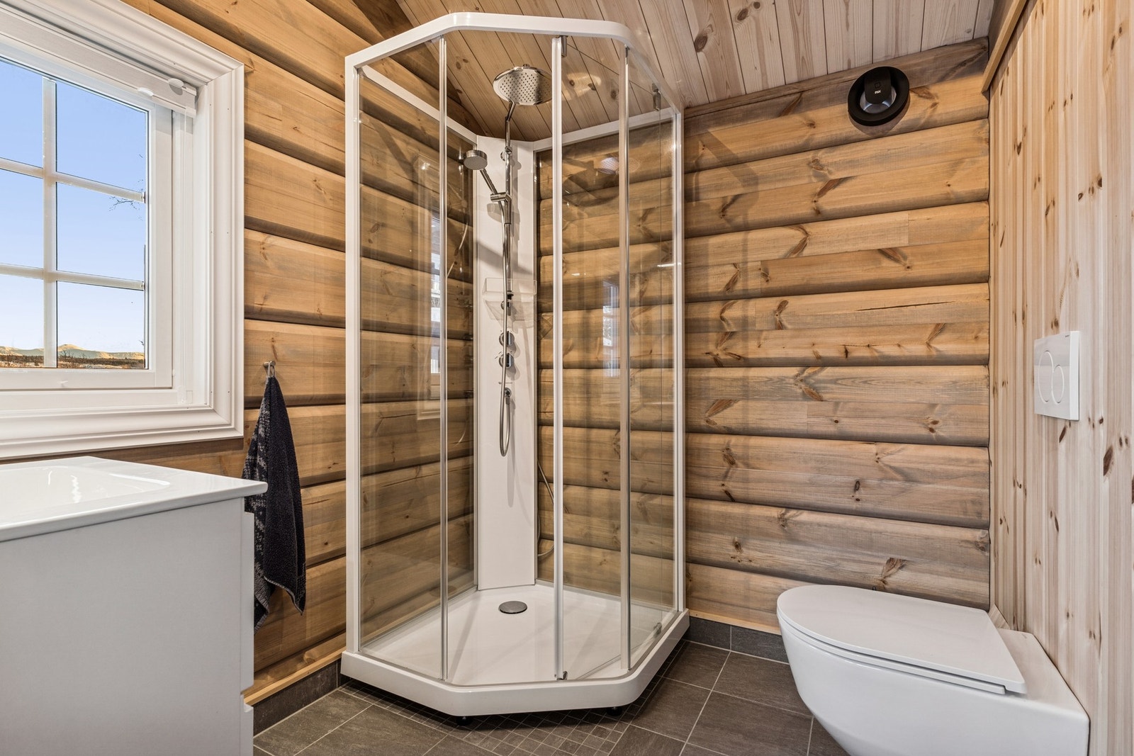 Bad i anneks. Flis på gulv med gulvvarme, panel og behandlede tømmervegger, panel i tak. Mekanisk avtrekk. Galleribilde
