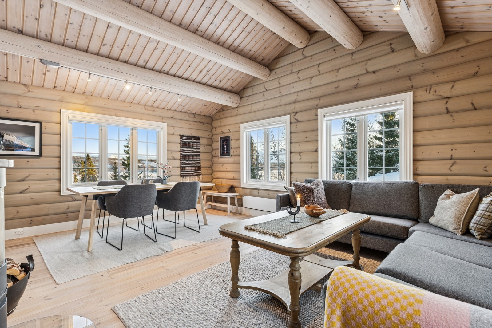 Lys og romslig stue med tregulv, tømmervegger og -tak. Galleribilde