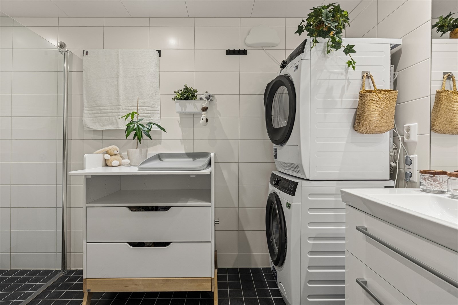 Delikat og moderne bad med servant, dusjhjørne og toalett. Opplegg til vaskemaskin og tørketrommel. Galleribilde