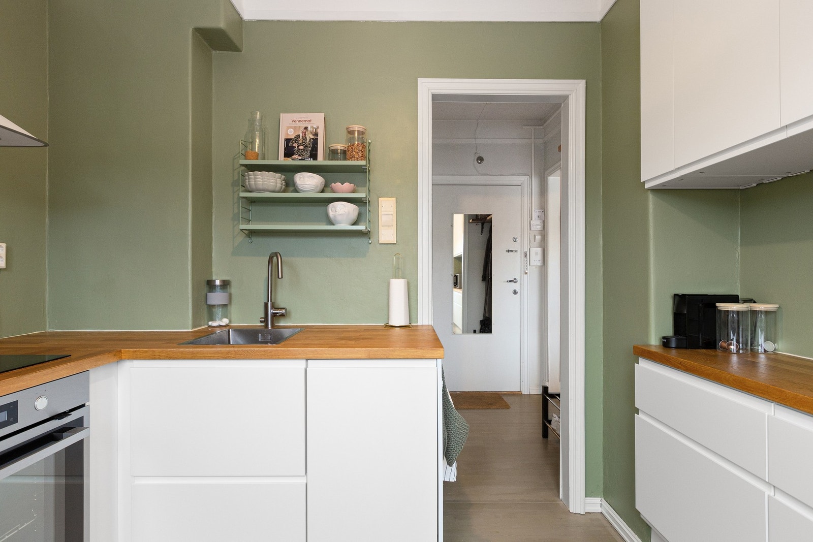 Kjøkkenet har stilren kjøkkeninnredning fra 2018 med hvite fronter og heltre benkeplate. Galleribilde