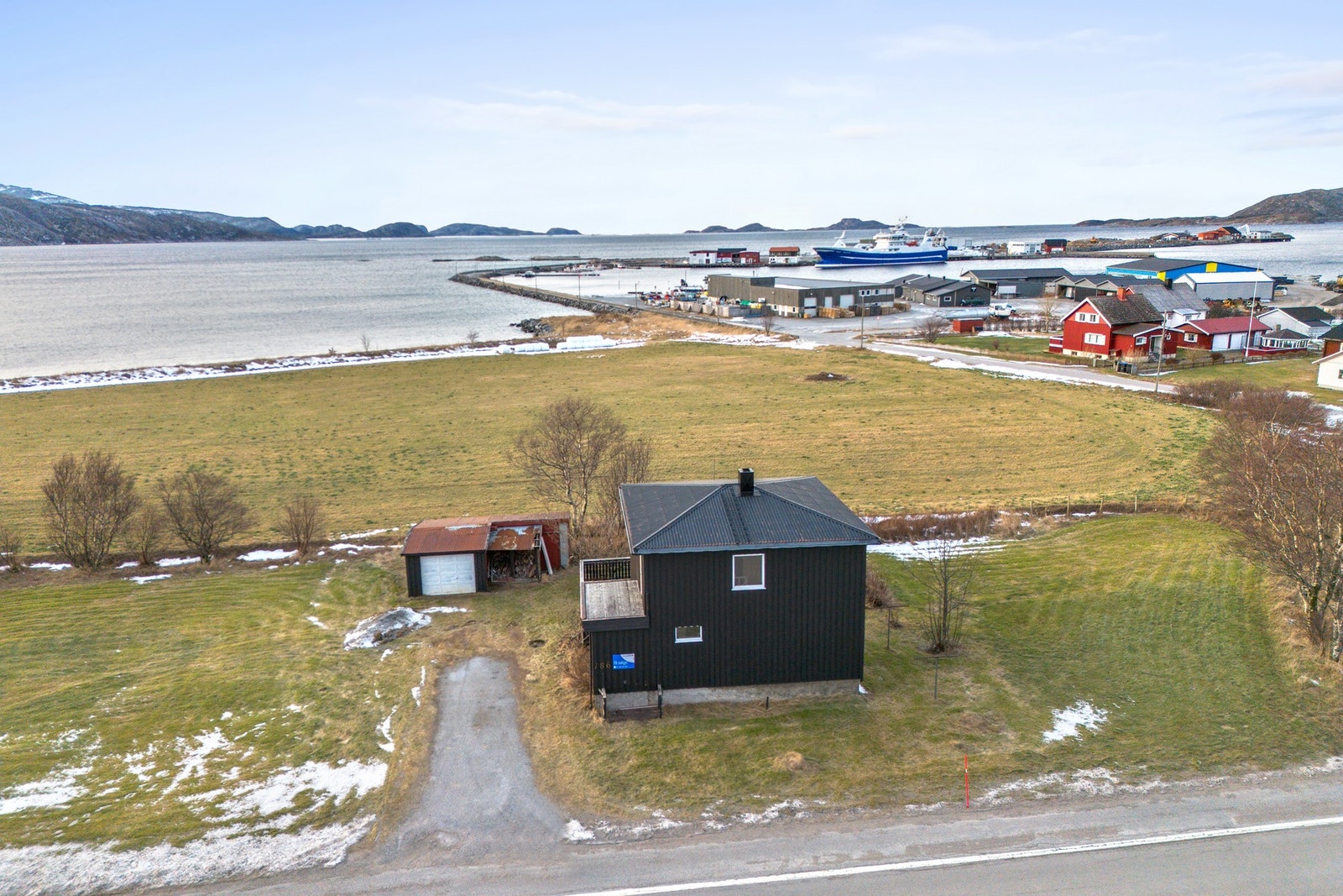 Den romslige tomten strekker seg i både nordøstlig og sørvestlig retning fra boligeiendommen, langs vegen. Galleribilde