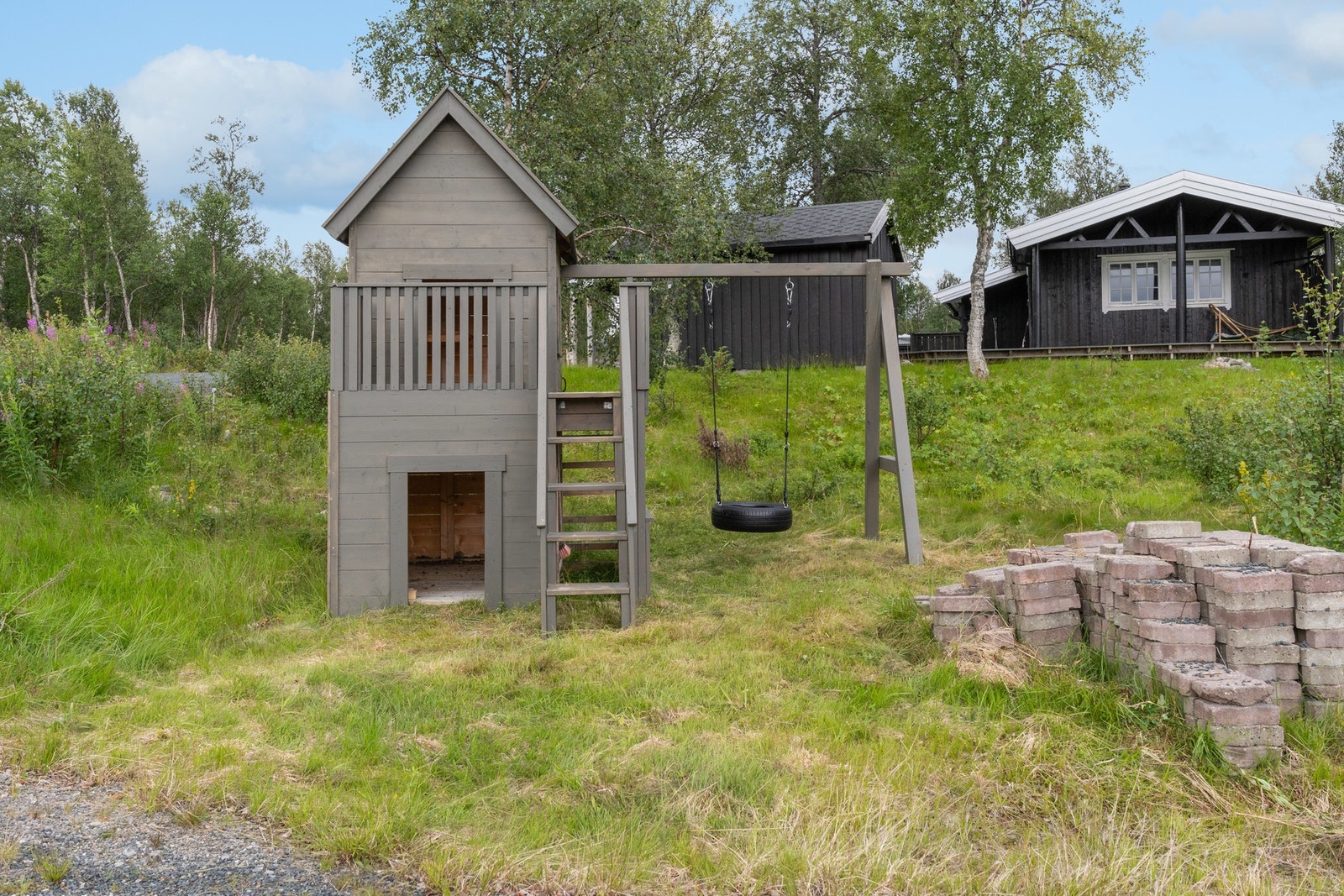 Flott opparbeidet tomt (flat) med gårdsplass, plen og lekeapparat. Galleribilde