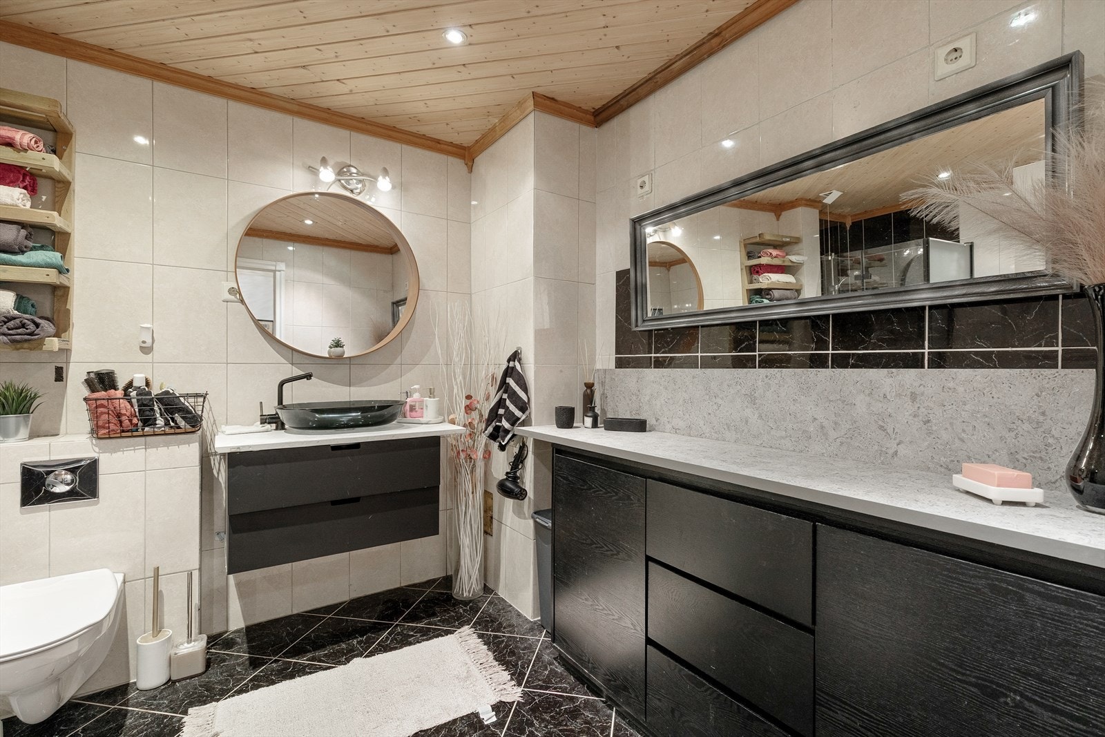 Bad med flislagte golv- og veggar. Vegghengt toalett, og servant med skuffer under. Galleribilde