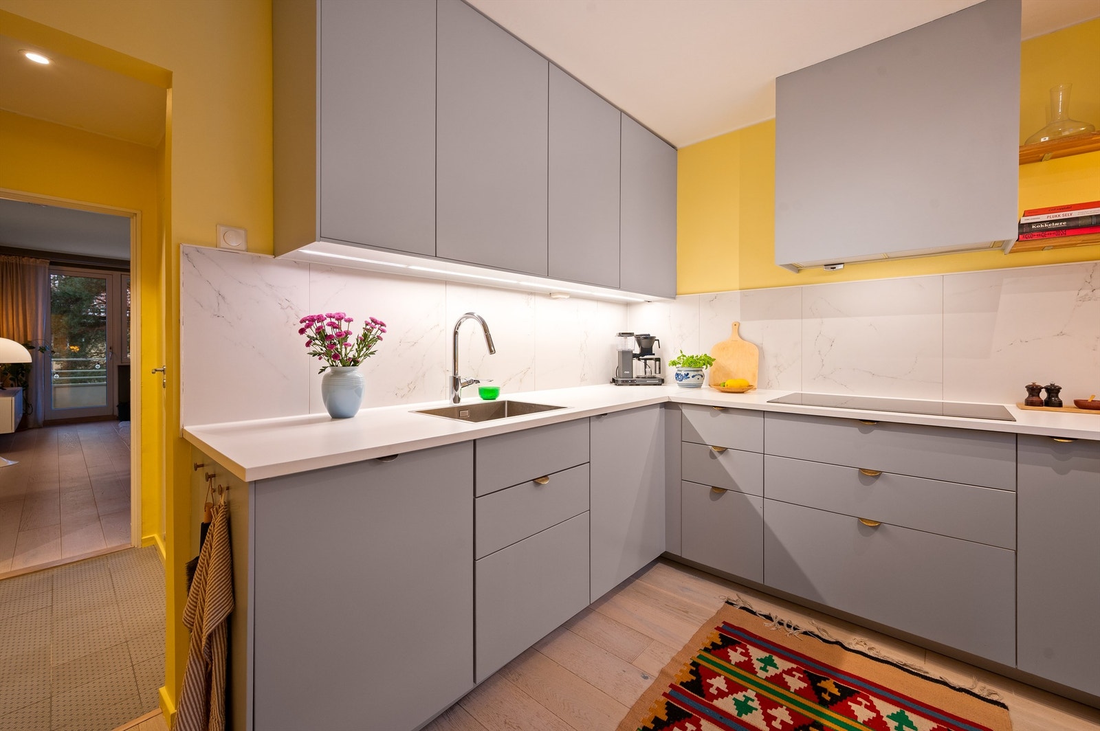 Hvitevarene er sømløst integrerte og består av platetopp, stekeovn, oppvaskmaskin og kjøleskap. Over kokesonen er det montert en kullfilterventilator. Galleribilde