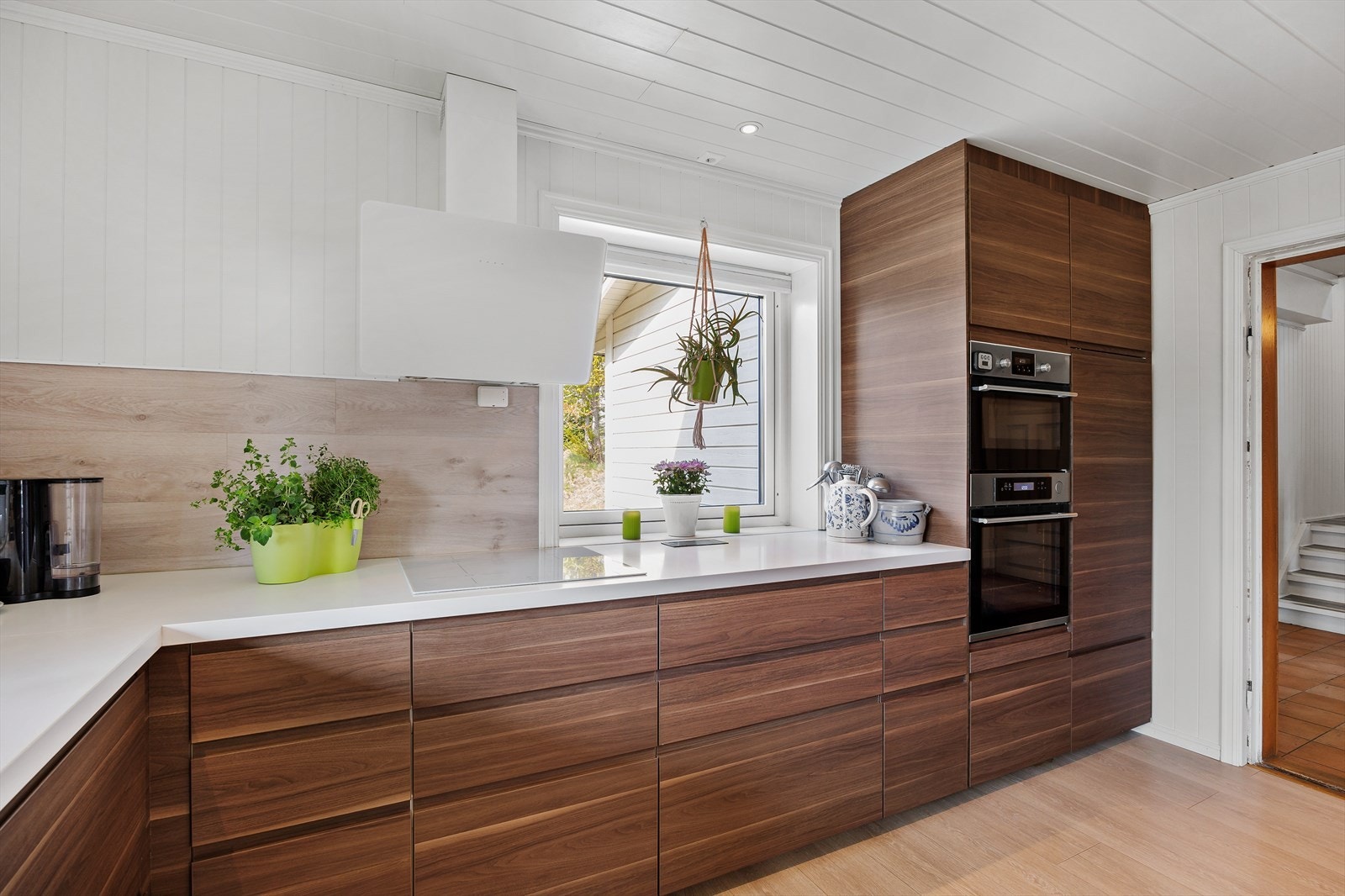 Kjøkkeninnredningen består av skap med brune glatte fronter og benkeplate i laminat. Integrerte hvitevarer. Galleribilde