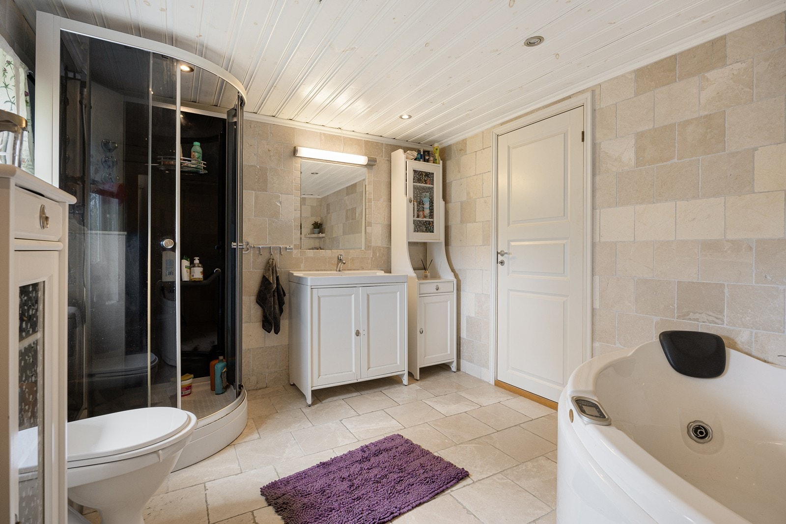 Baderomsinnredningen består av et hvitt servantskap, et høyskap i samme stil og et speil med belysning over servanten. Galleribilde