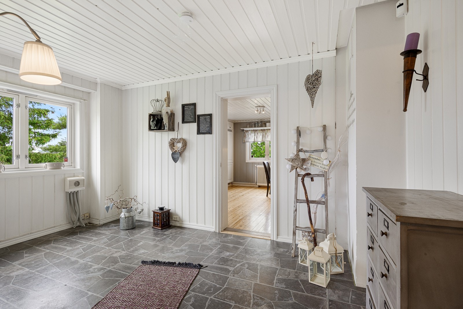 Vindfanget ligger i tilknytning til en gang med praktisk gjestetoalett. Yttertøyet ryddes enkelt bort i en stor og plassbygget skyvedørsgarderobe i vindfanget. Galleribilde