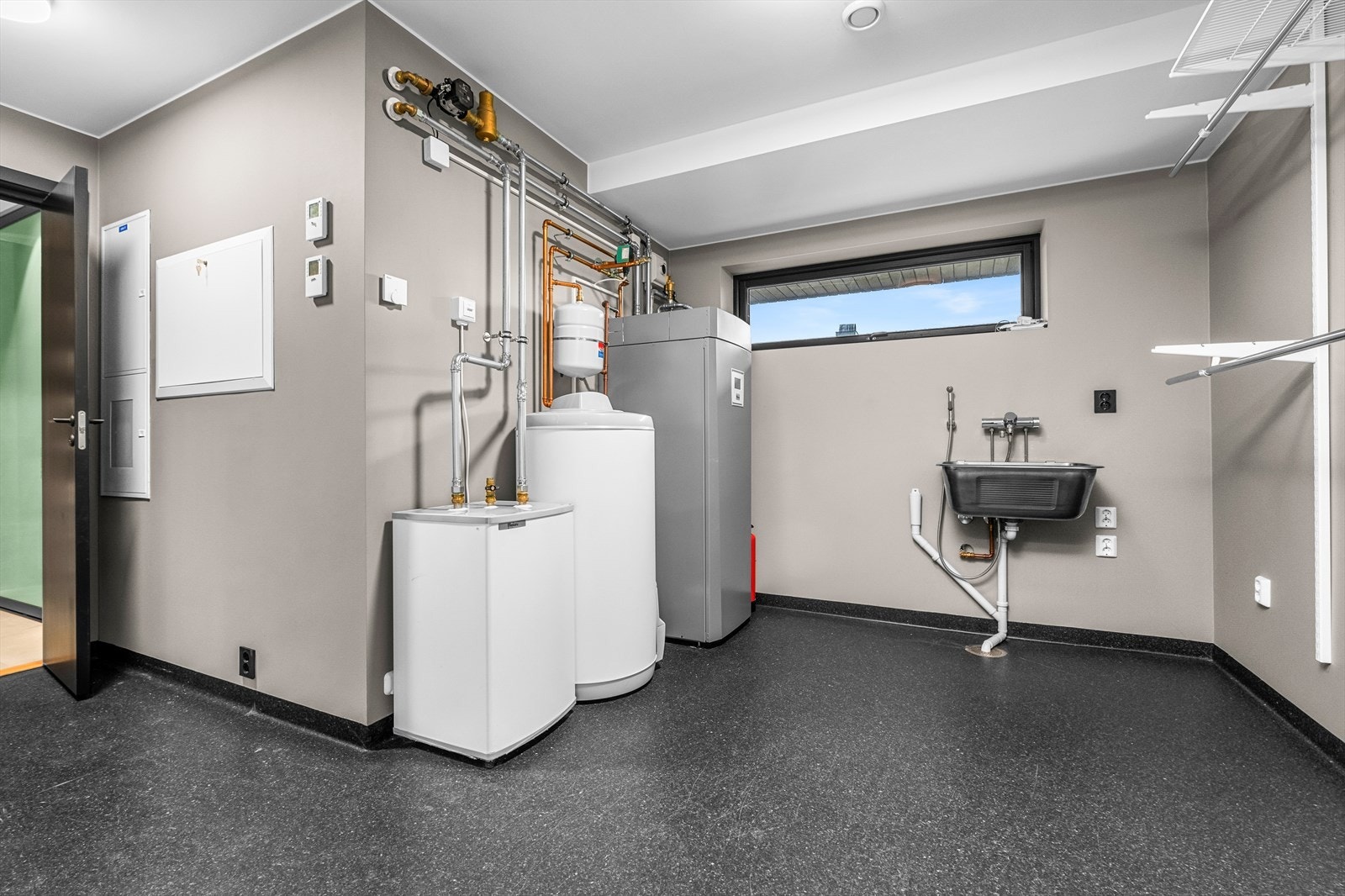 Eget vaskerom på 11,5m² som er utstyrt med bereder, opplegg for vaskemaskin, rørfordelingsskap, skyllekum, stoppekrav, vannmåler og sikringsskap. Rommets gode størrelse gir godt med oppbevaringsplass og smarte garderobeløsninger. Galleribilde