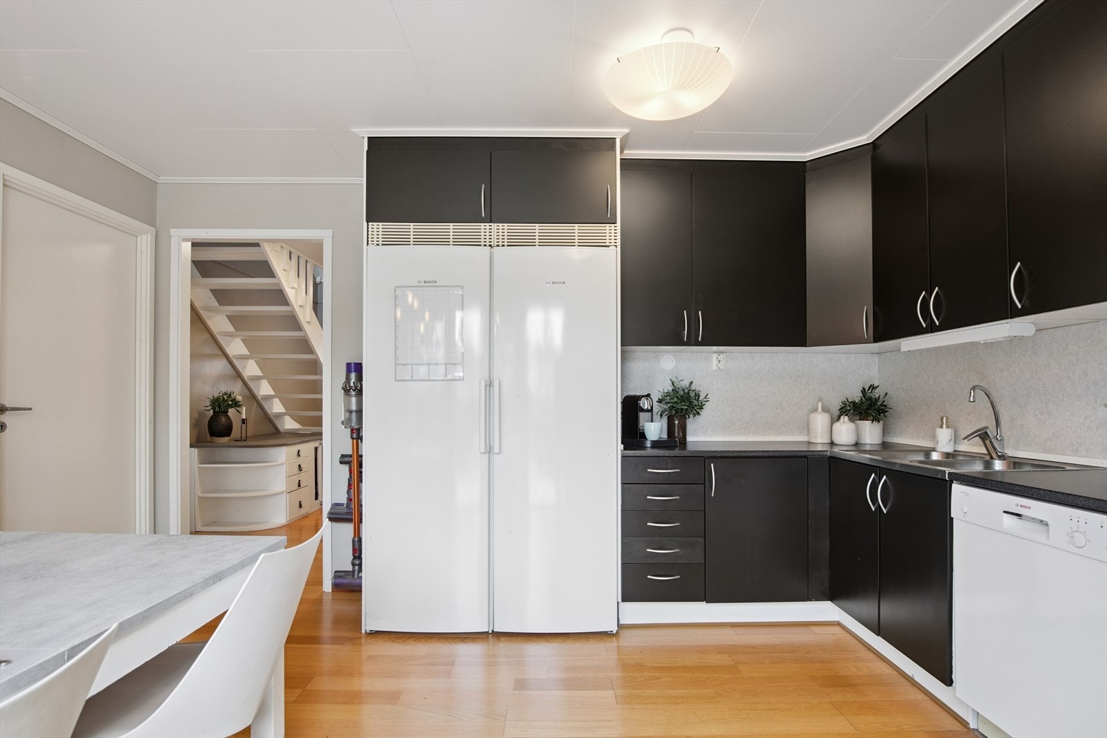 Kjøkkenet har en takhøy, stilren innredning med god skapplass. Dekorative kitchen-boards mellom benk og overskap. Galleribilde