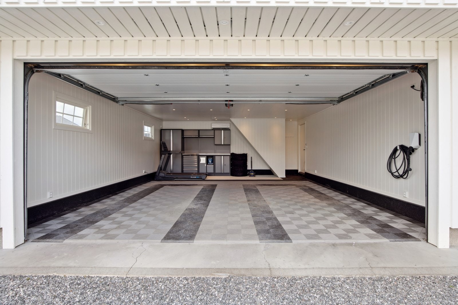 Romslig dobbeltgarasje med automatisk port og store oppbevaringsmuligheter. Galleribilde