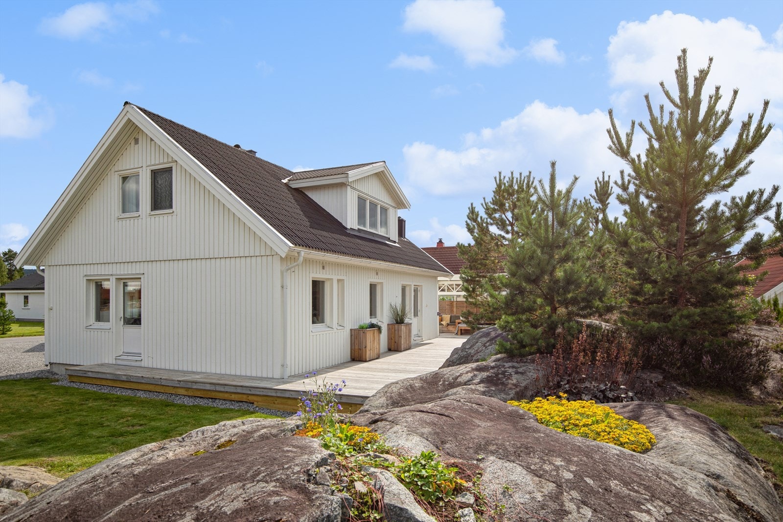 Meget pent opparbeidet tomt, der fjell i dagen og stedlig vegetasjon utgjør et naturlig og dekorativt skille i nabogrensen. Galleribilde