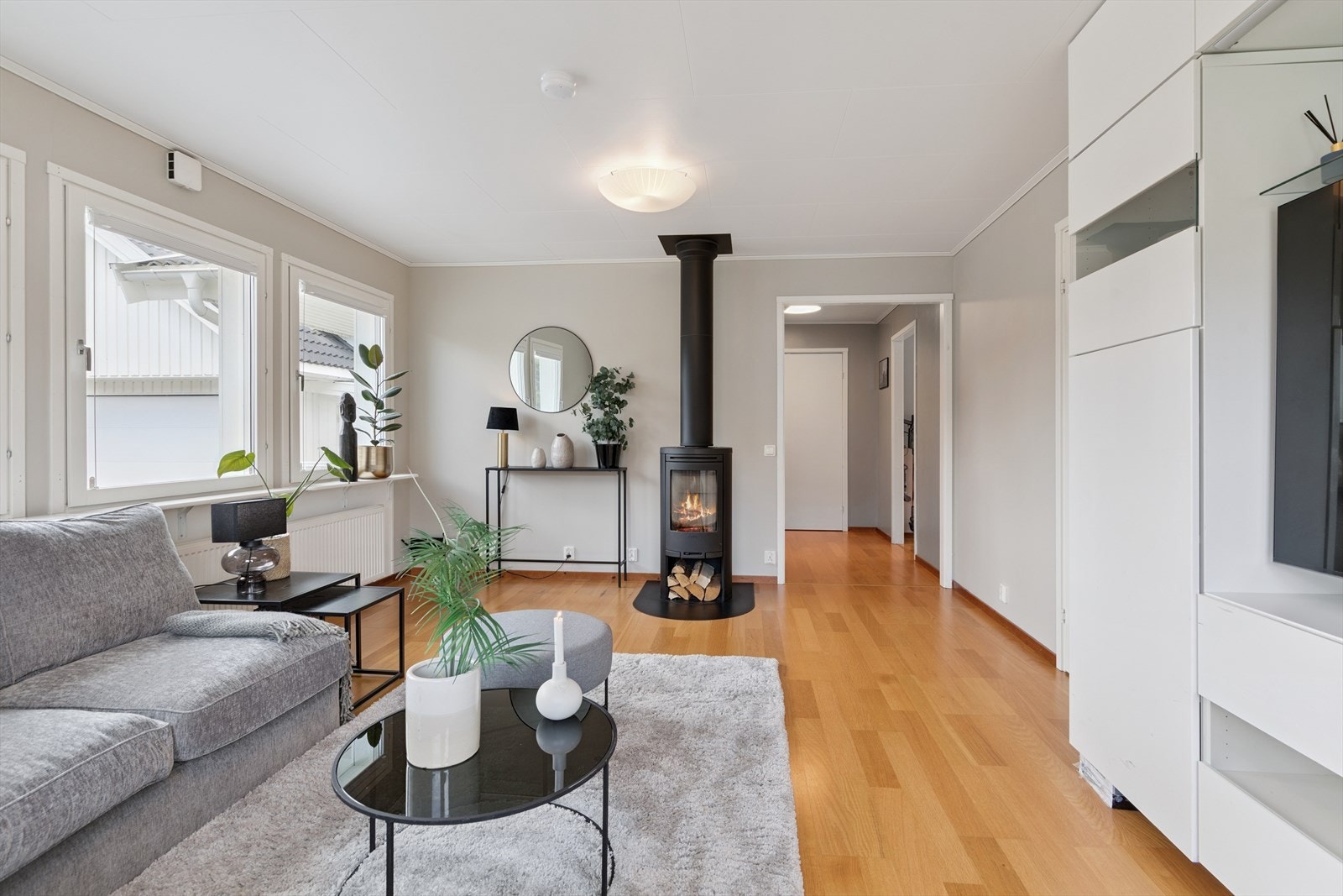 I første etasje ligger stuen med en moderne peisovn sentralt plassert i oppholdsarealet. Galleribilde