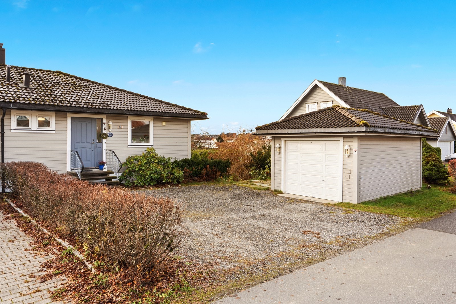 Parkering på egen gårdsplass foran inngangsparti. Enkel garasje. Galleribilde