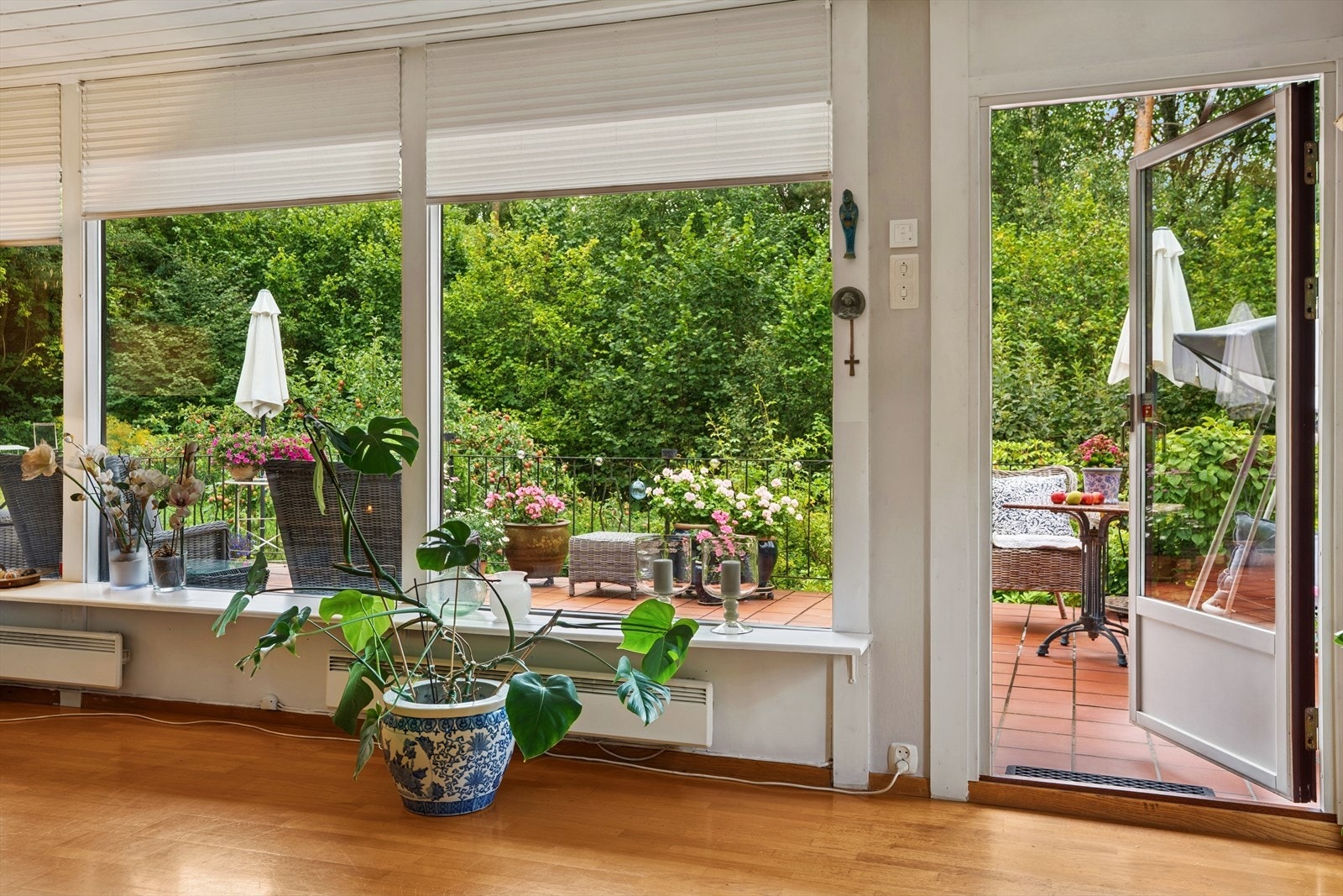 Stuen har store vindusflater som gir rikelig med naturlig lysinnslipp, og rammer inn utsynet mot den nydelige hagen. Galleribilde