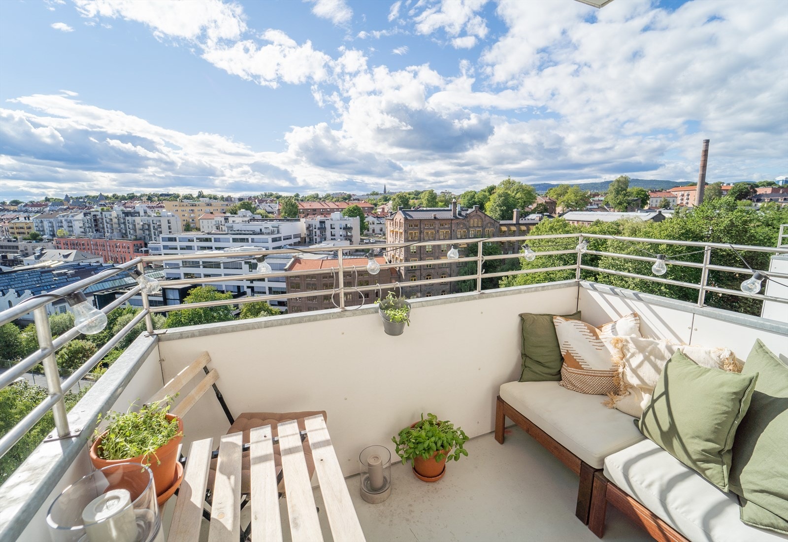 Om sommeren kan du nyte sol fra tidlig til sent på balkongen. Å bo midt i byen, med en slik utsikt er ikke mange forunt! Bildet er tatt sommeren 2022, og selger har senere lagt nytt gulv på balkongen. Galleribilde