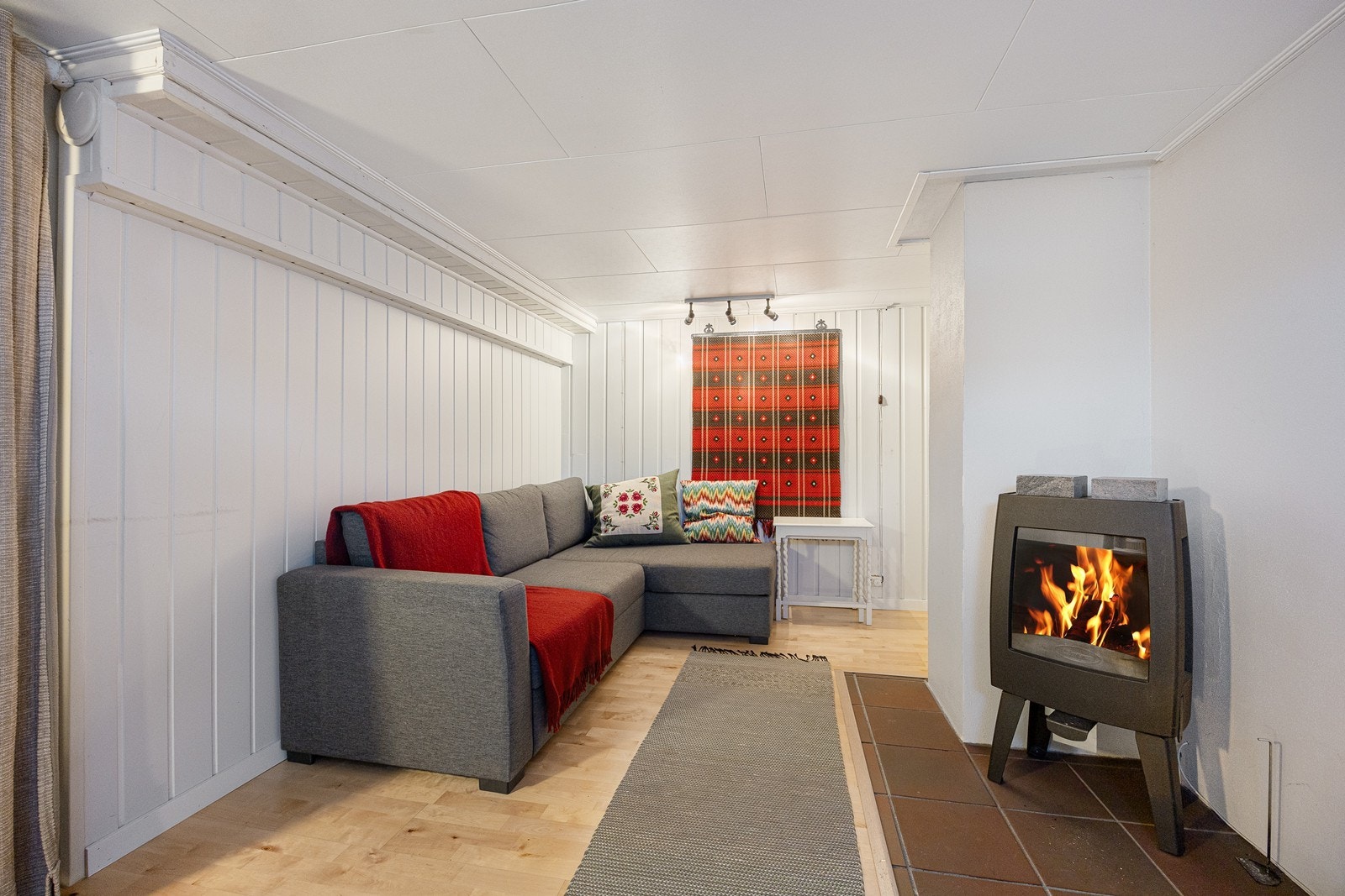 Ett av de innredede rommene har en moderne peisovn. Galleribilde