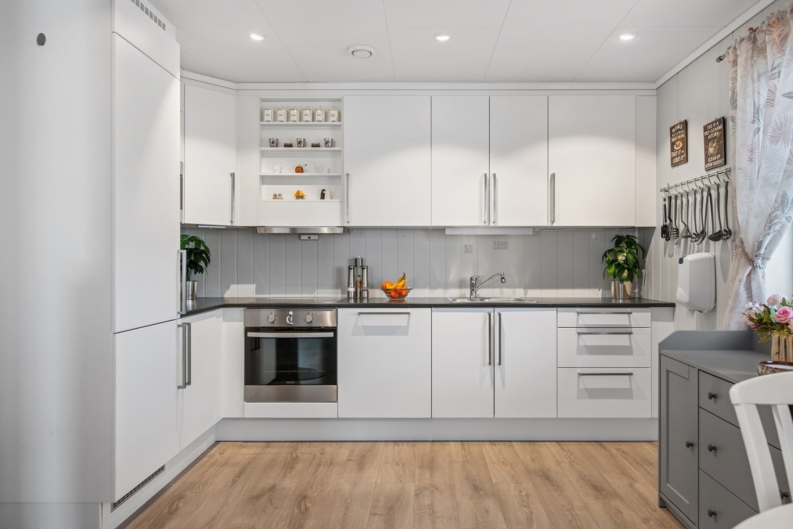 Kjøkkenet har en stilren innredning med glatte fronter og integrerte hvitevarer. Galleribilde