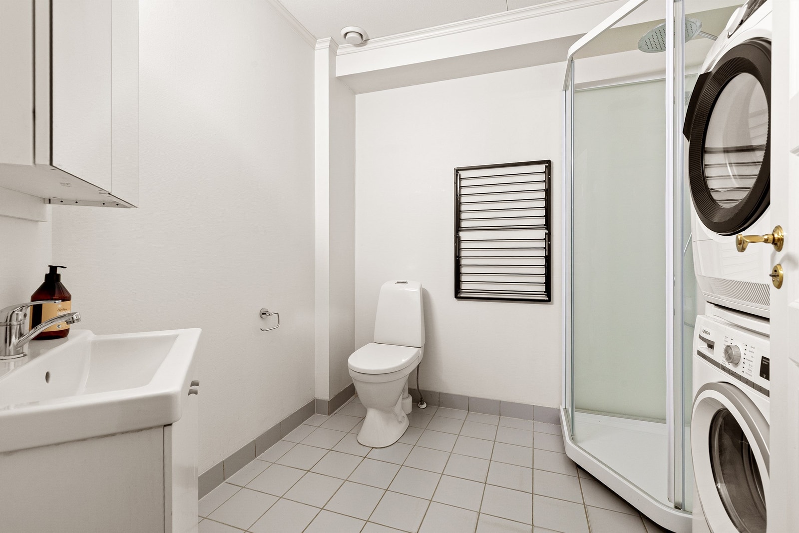 Bad i 1.etg med flislagt gulv med varme. Innredet med dusjkabinett (2025), toalett, servantskap med speil, samt opplegg for vaskemaskin og tørketrommel Galleribilde