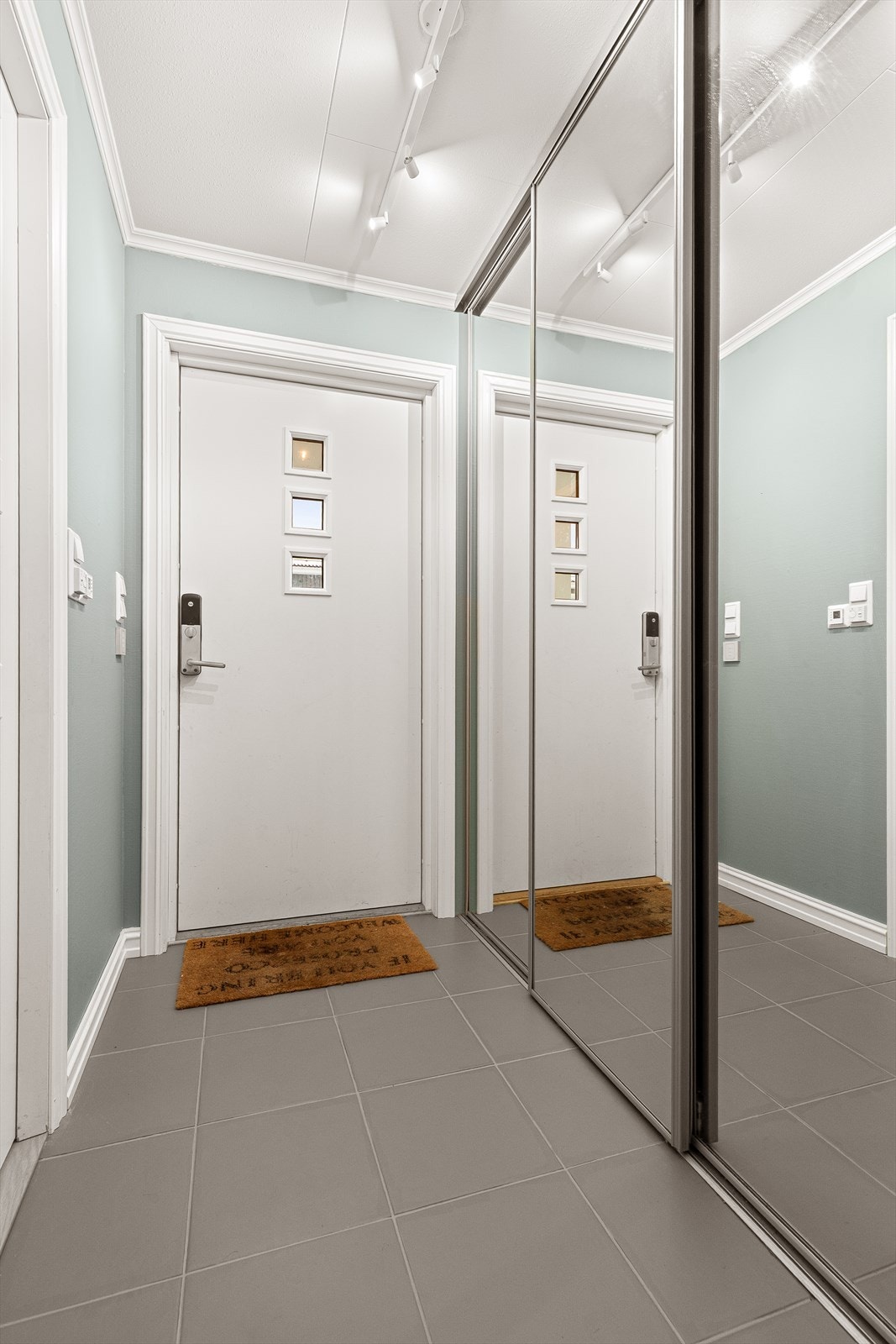 Velkommen inn. Flislagt entré med gulvvarme og praktisk integrert skyvedørsgarderobe Galleribilde