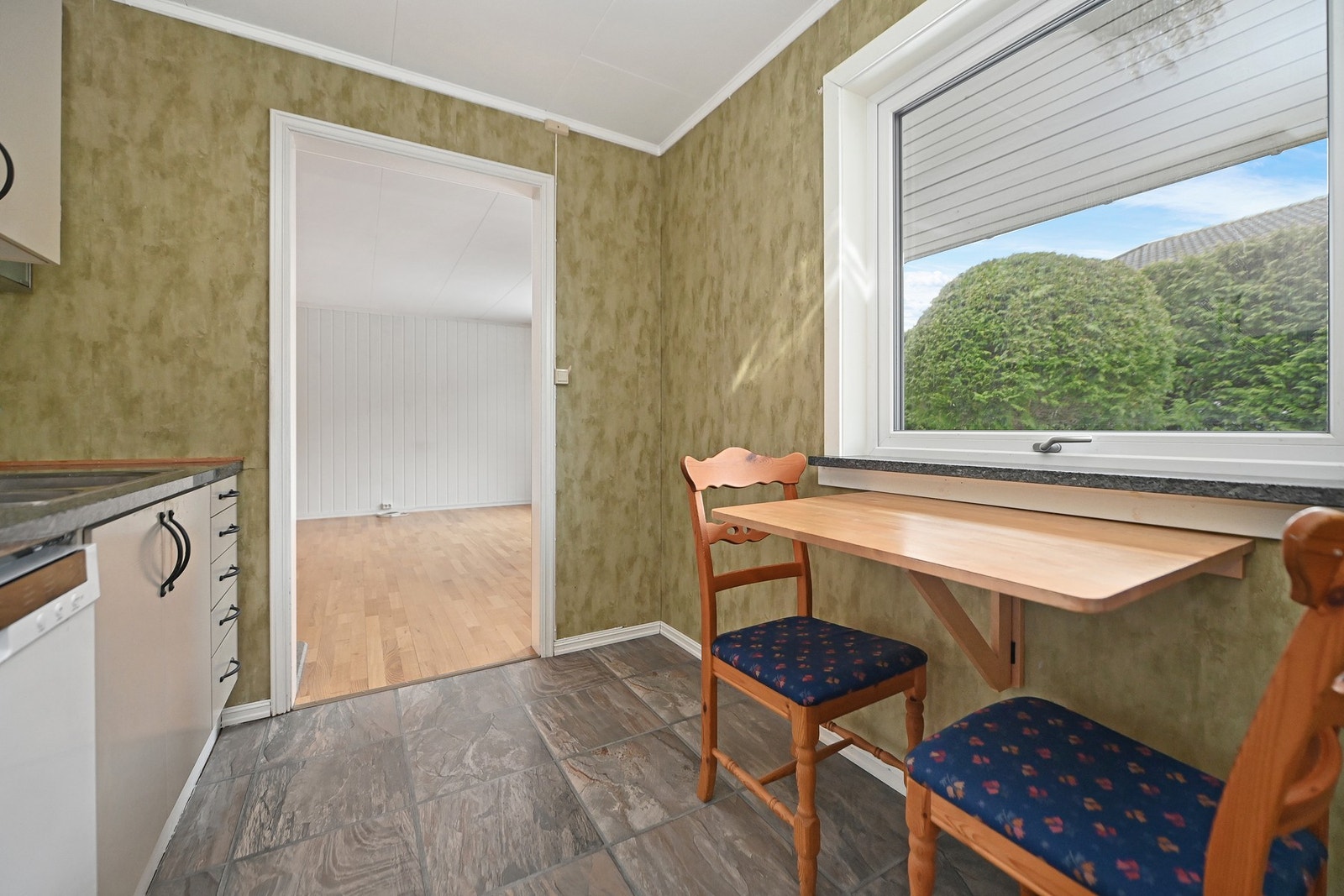 Kjøkken med flislagt gulv og vindu som gir godt lysinnslipp. Adkomst til stue gjennom åpen dør. Galleribilde