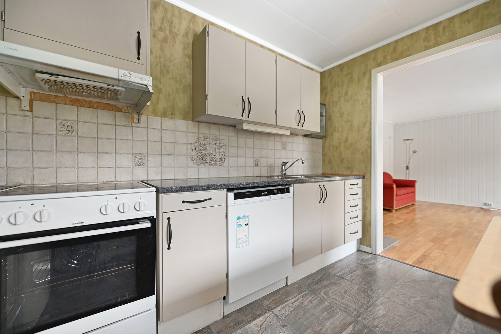 Kjøkken med hvitevarer, fliser på vegg og god skapplass. Åpen løsning mot stue. Galleribilde