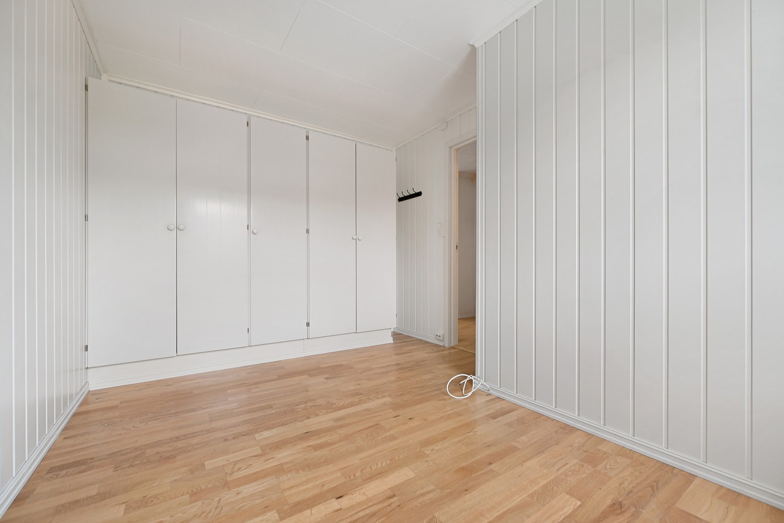 Lyse vegger, innebygde skap og parkettgulv gir et praktisk og stilrent rom. Galleribilde