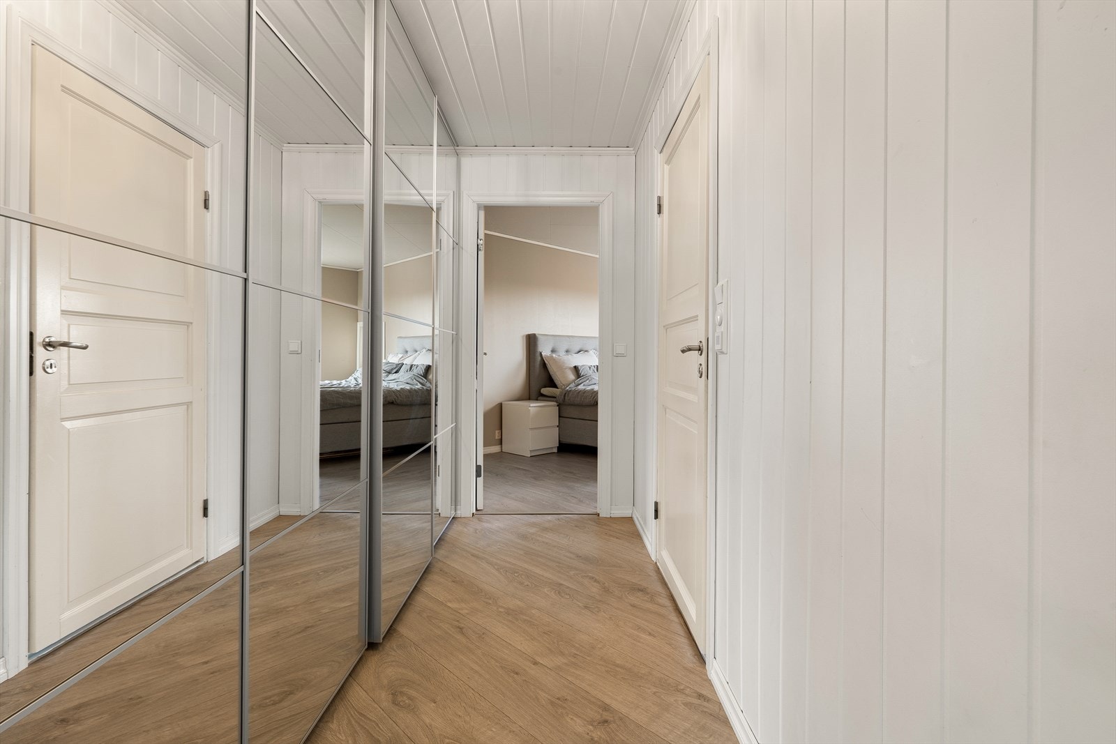 Skyvedørsgarderobe med speil langs vegg i gang gir godt med oppbevaringsplass Galleribilde