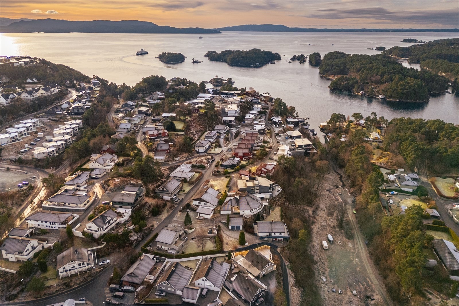Luftfoto av kystnært boligområde med øyer i bakgrunnen. Galleribilde