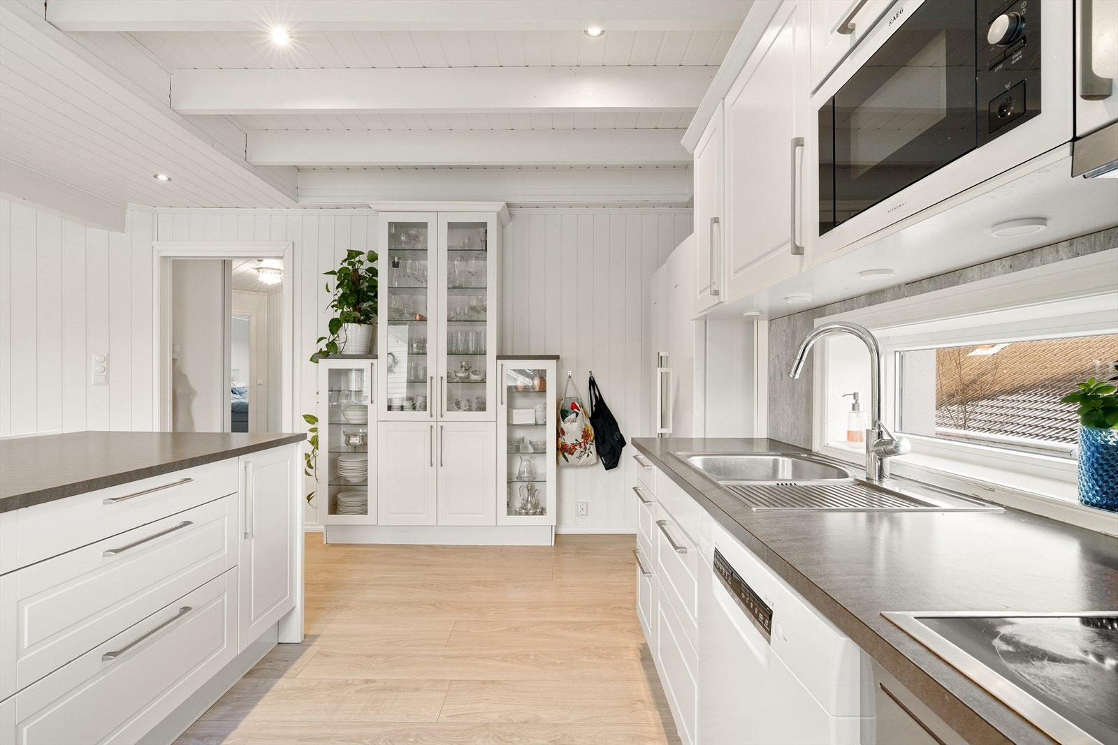 Kjøkkeninnredning med lyse, profilerte fronter og laminert benkeplate Galleribilde