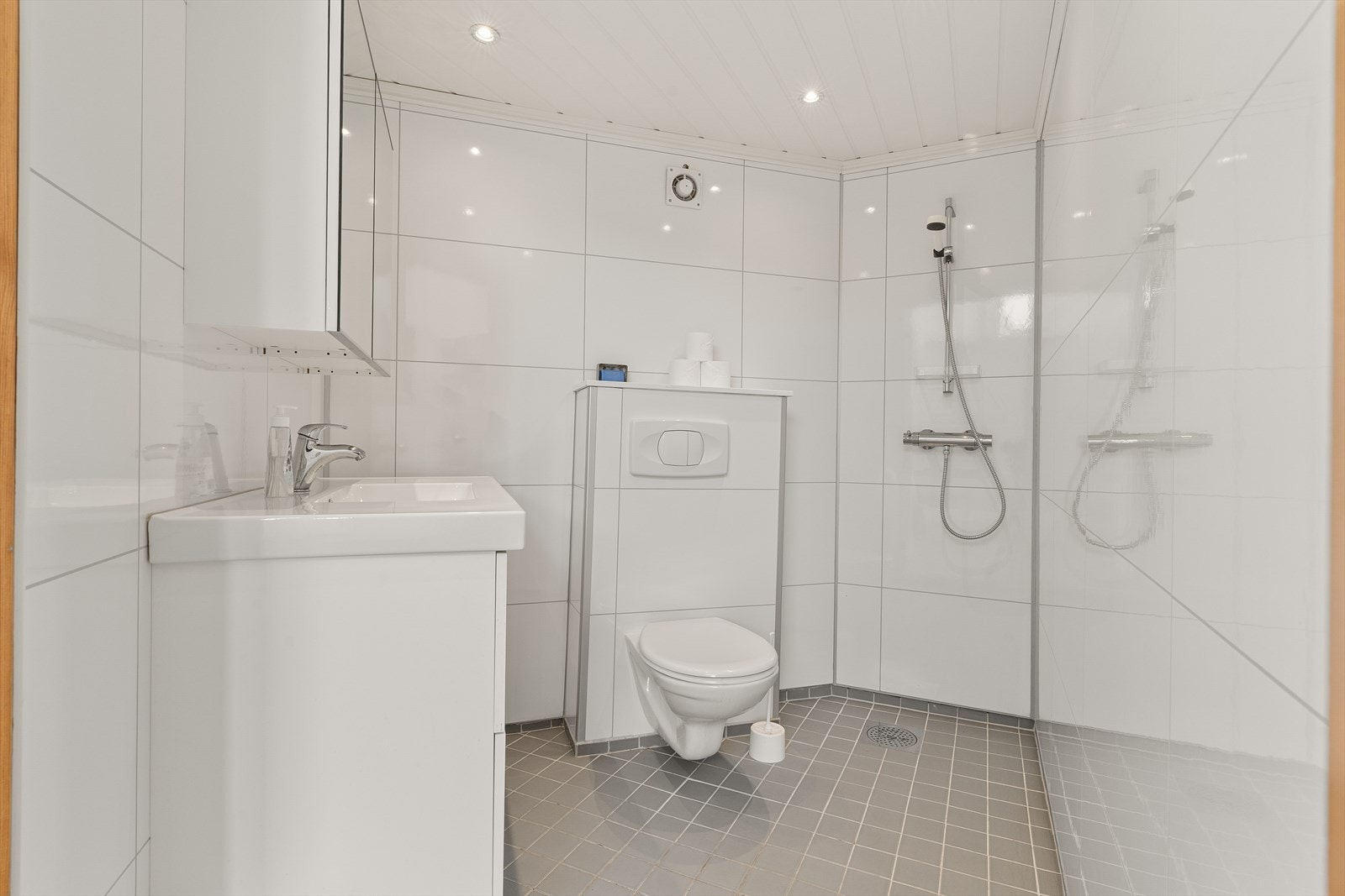 Badet er pusset opp i 2015 og er innredet med servant i møbel, speilskap, vegghengt toalett og dusj Galleribilde