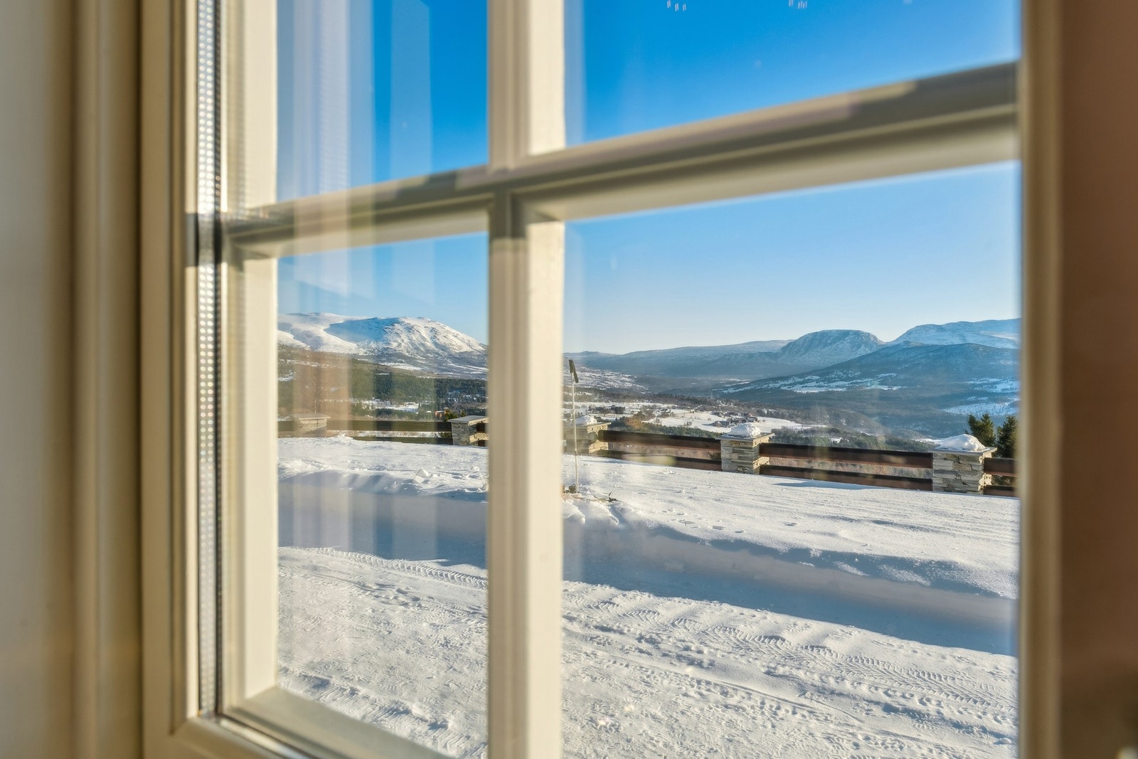 Fra stua har man fantastisk utsikt mot Oppdal og fjellene omkring, samtidig som hyttas fine plassering i terrenget hindrer innsyn Galleribilde