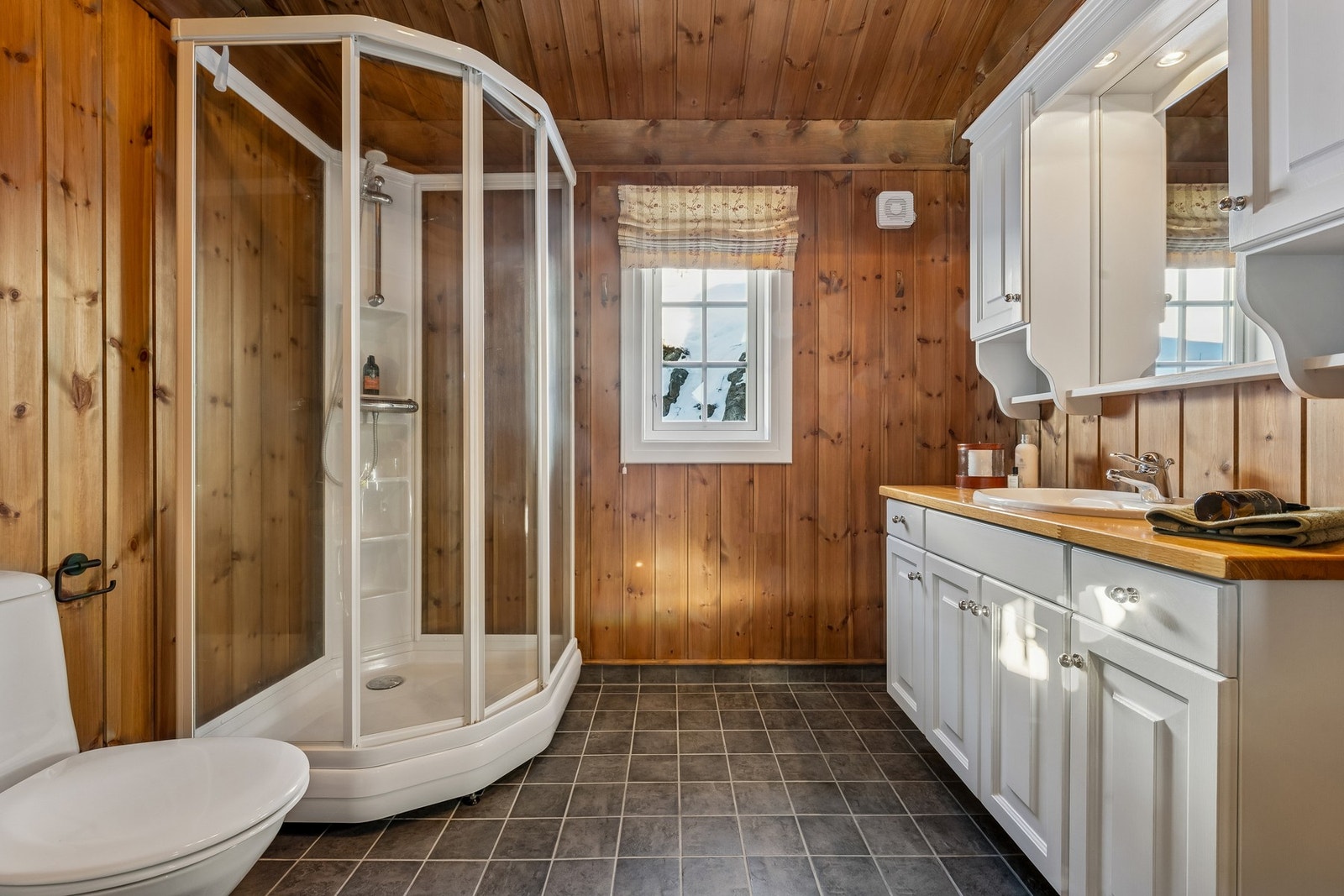 Badet har varme i gulvet, avtrekksvifte og romslig dusjkabinett Galleribilde