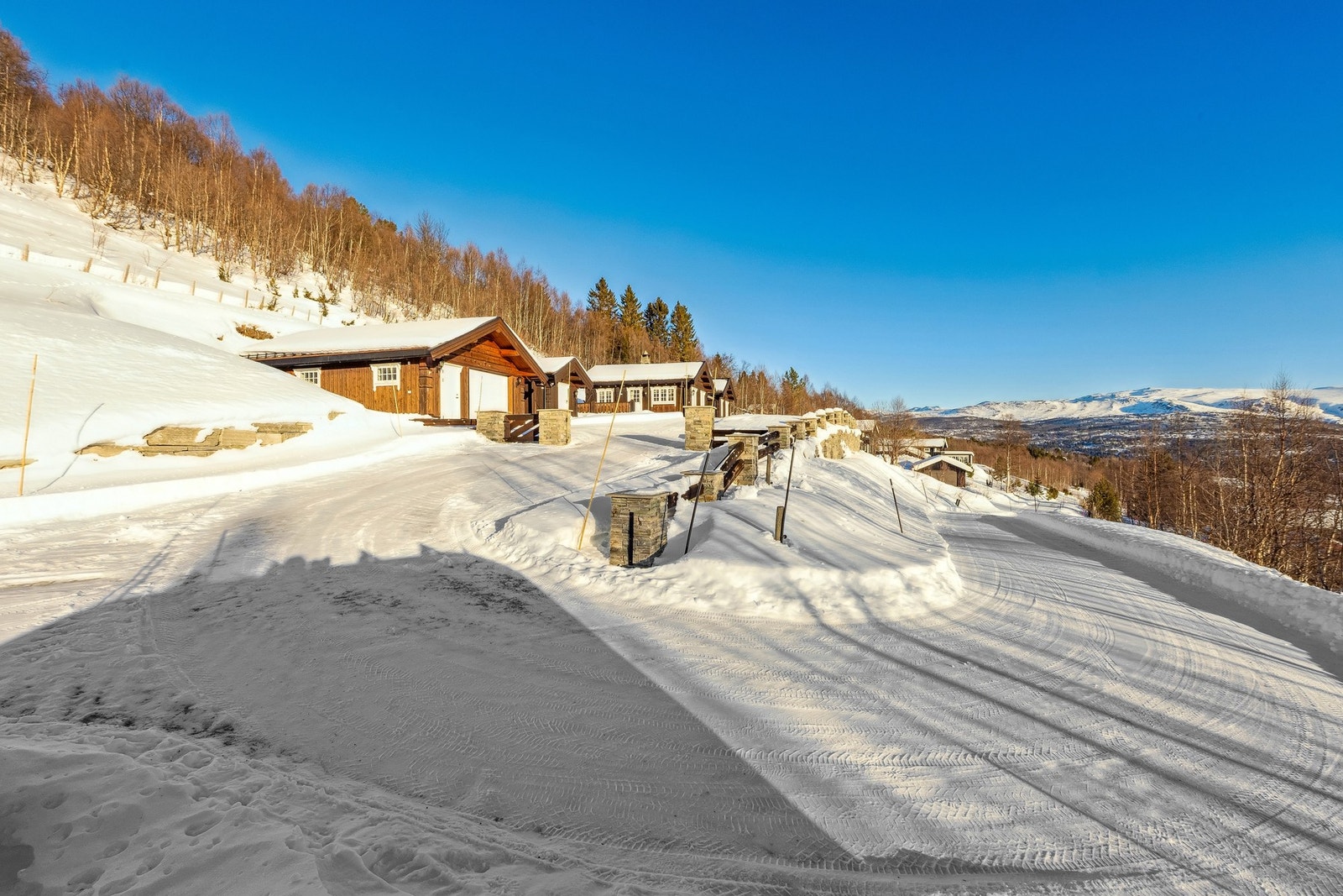 Eiendommen ligger skjermet øverst i veien og får ingen over seg. I tillegg til garasjen er det god plass til oppstilling av biler i nedre del av den store tomta Galleribilde