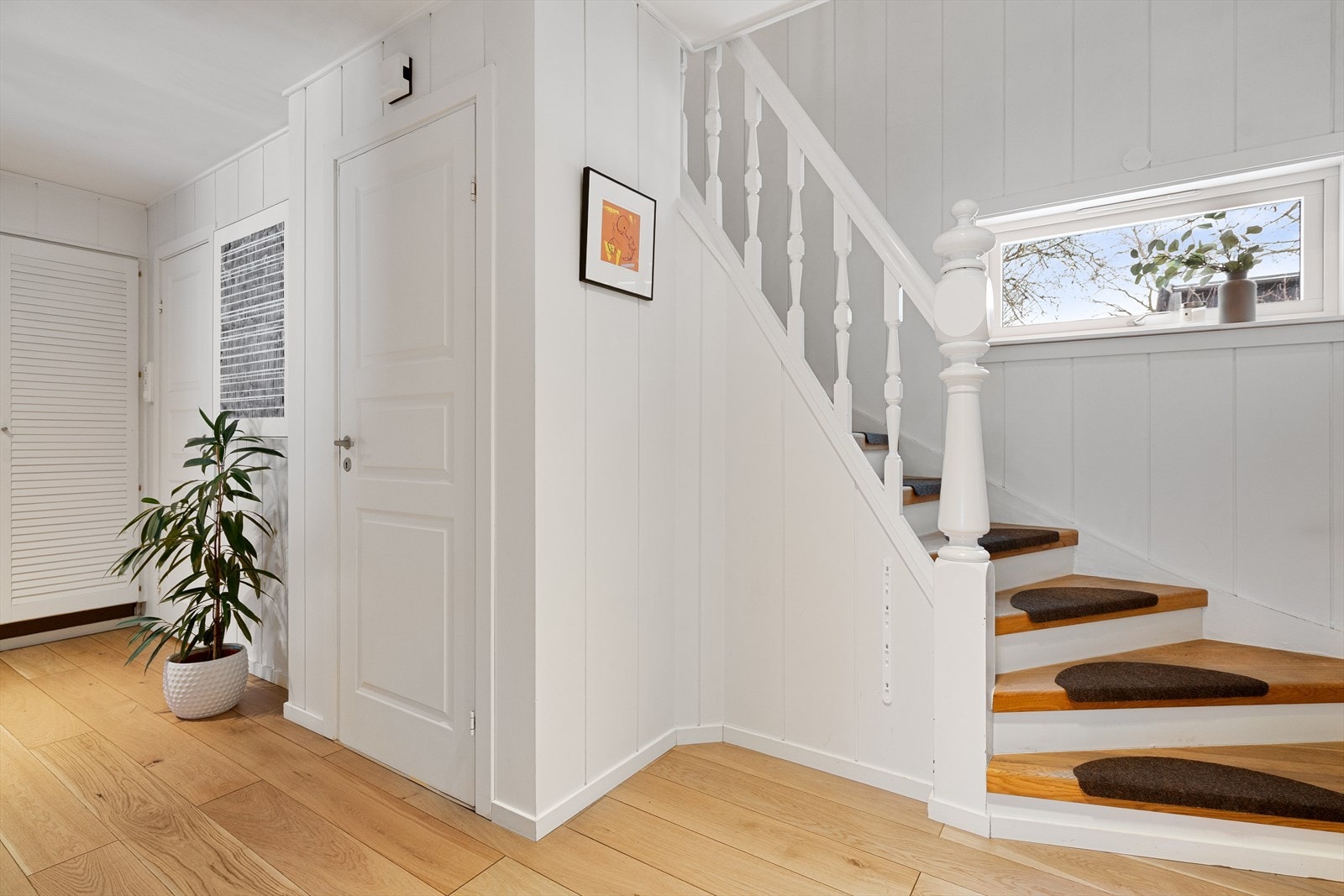 Gang i 1.etg. Døren på bildet er ned til kjelleren, med vaskerom, stor bod, kjøkken, kjellerstue og stort bad. Det er også egen inngang til kjeller Galleribilde